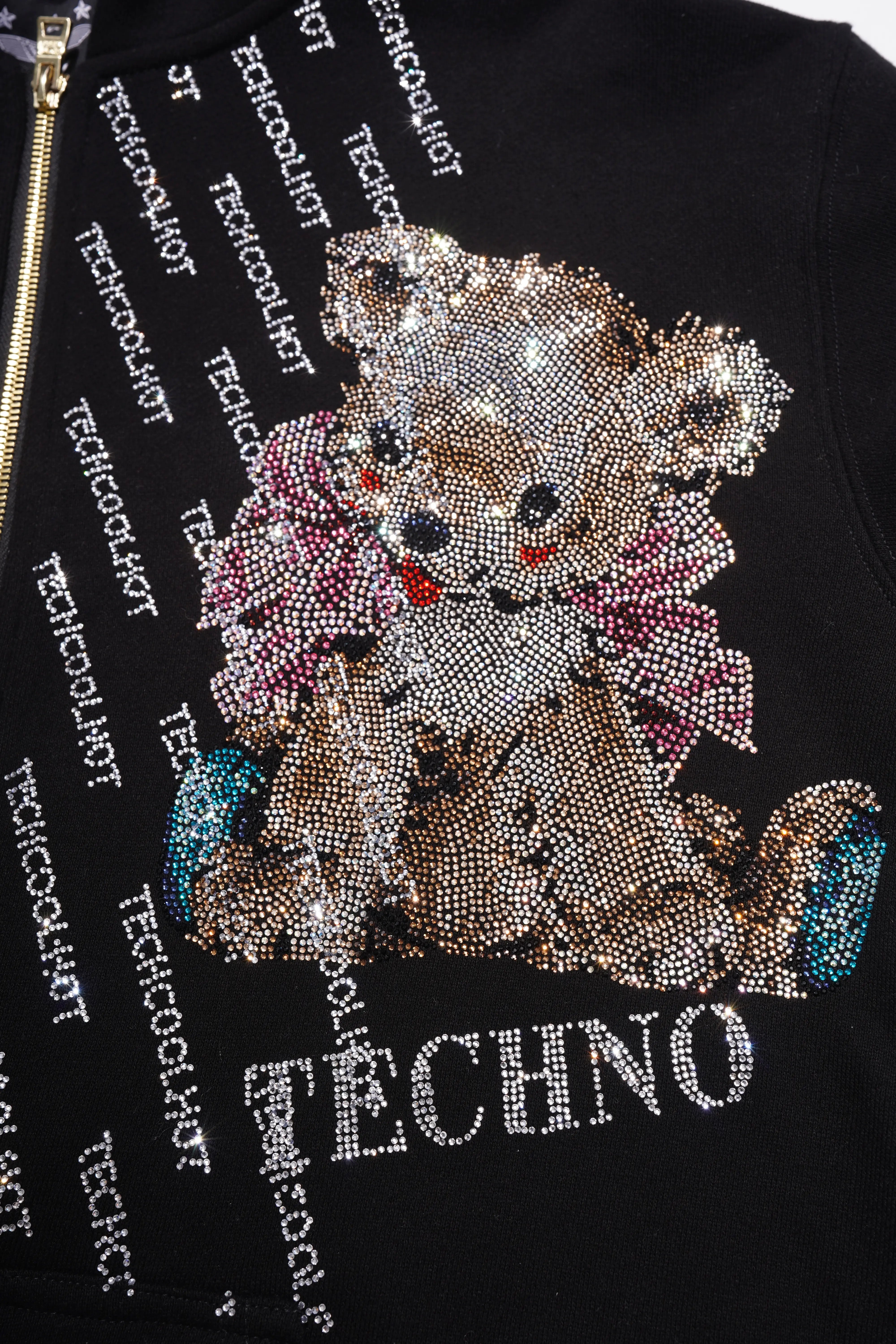 Black jacket with a rhinestone teddy bear design and 'TECHNO' text. Rhinestone Bear “TECHNO” Zip-Up Hoodie