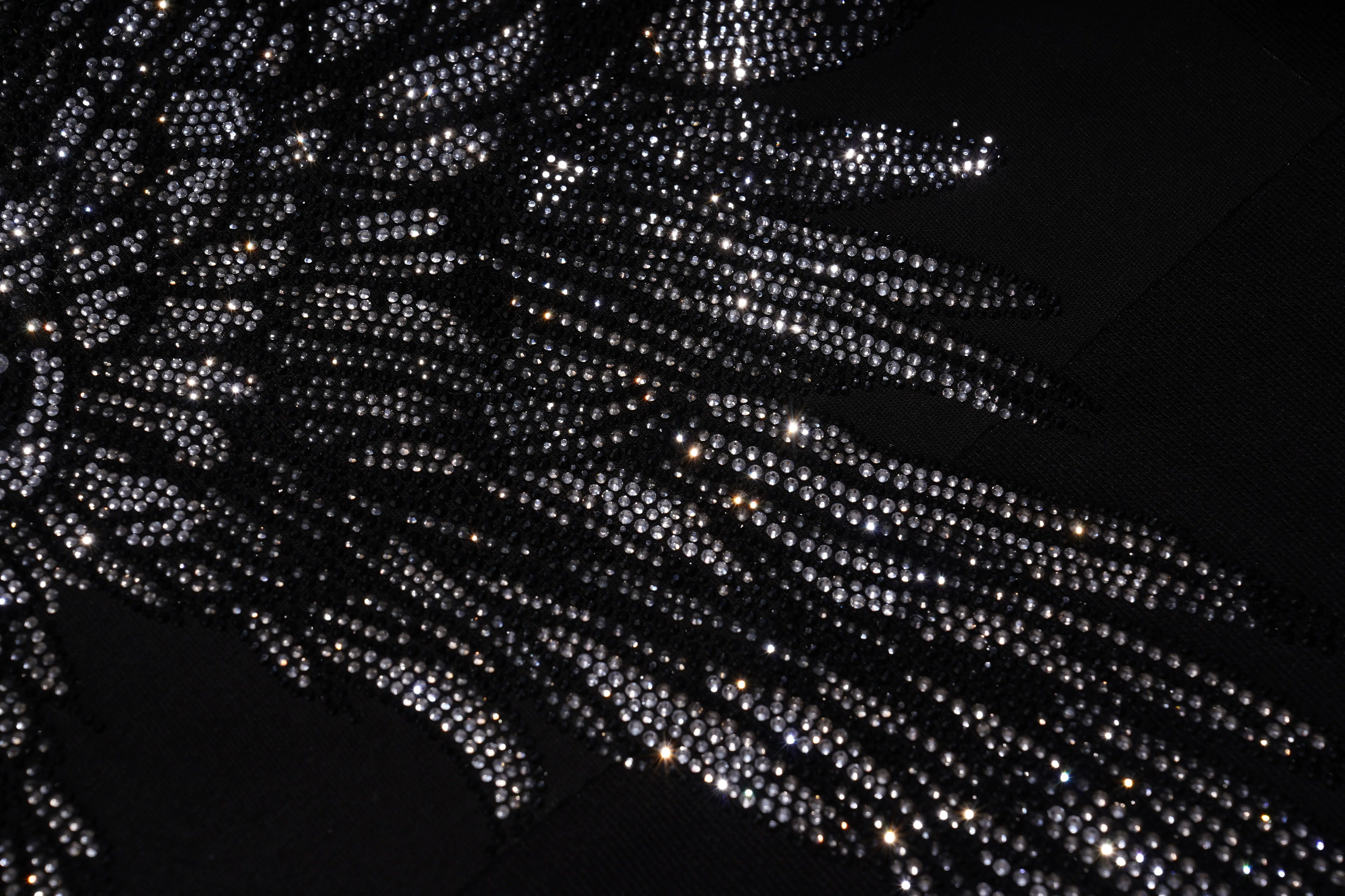 Close-up of a black dress with sparkling rhinestone details on a dark background, TCH 1976 Rhinestone Wings Sweatshirt