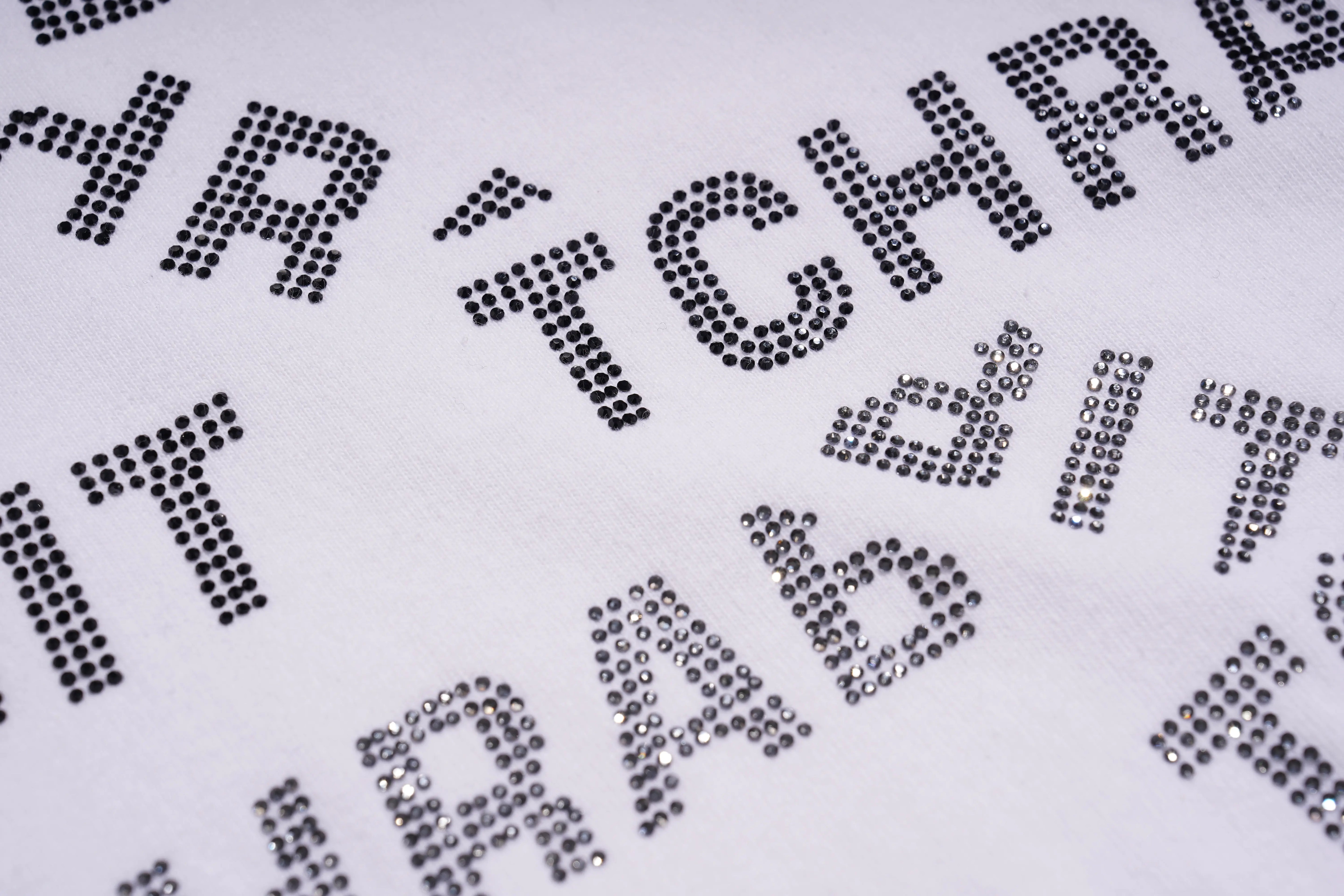 Close-up of rhinestone-embellished text on a white background, TCH All-Over TCHRABBIT Logo T-Shirt