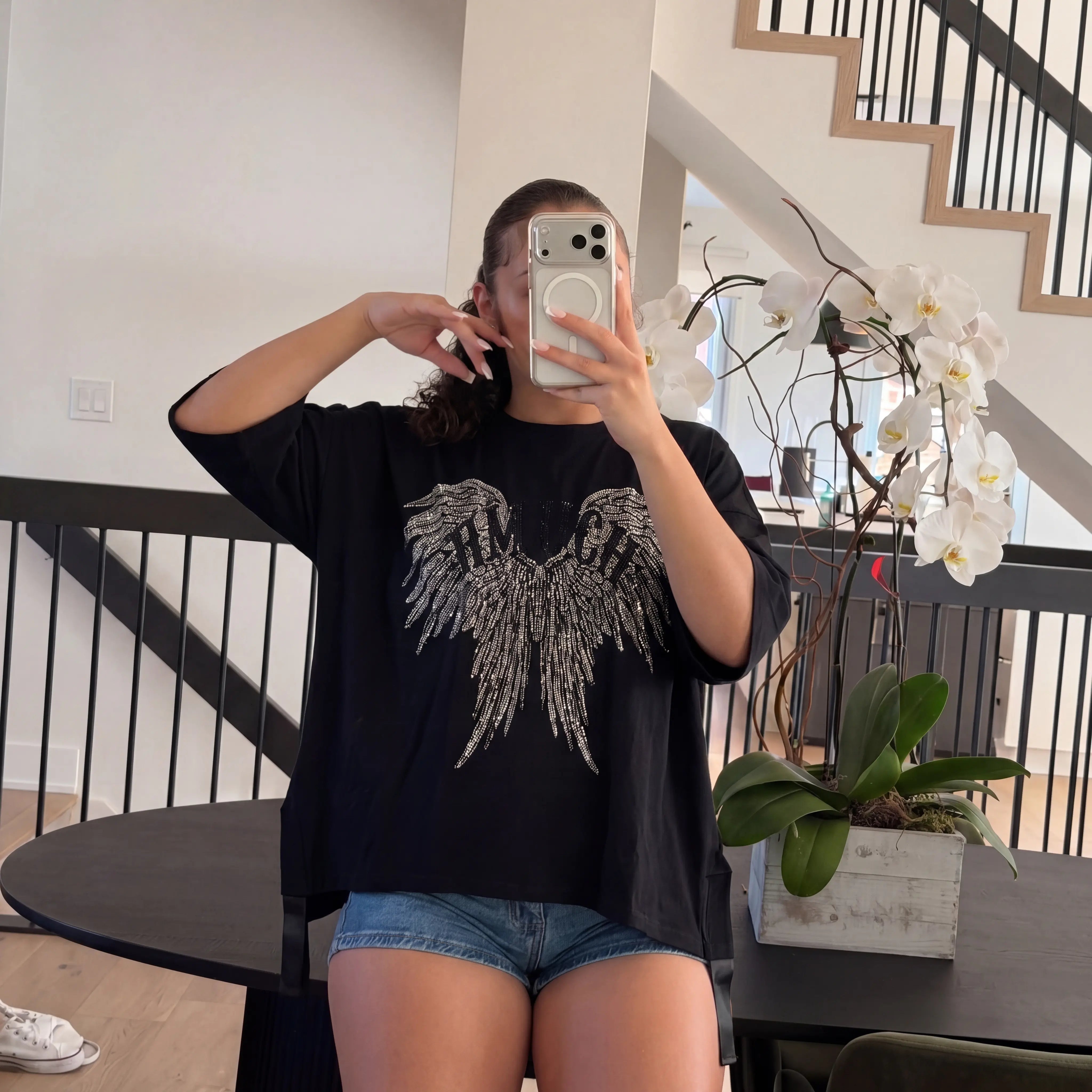 Person taking a mirror selfie wearing a black t-shirt with an eagle design in a home setting. TCH Angel Wings Rhinestone Oversized T-Shirt