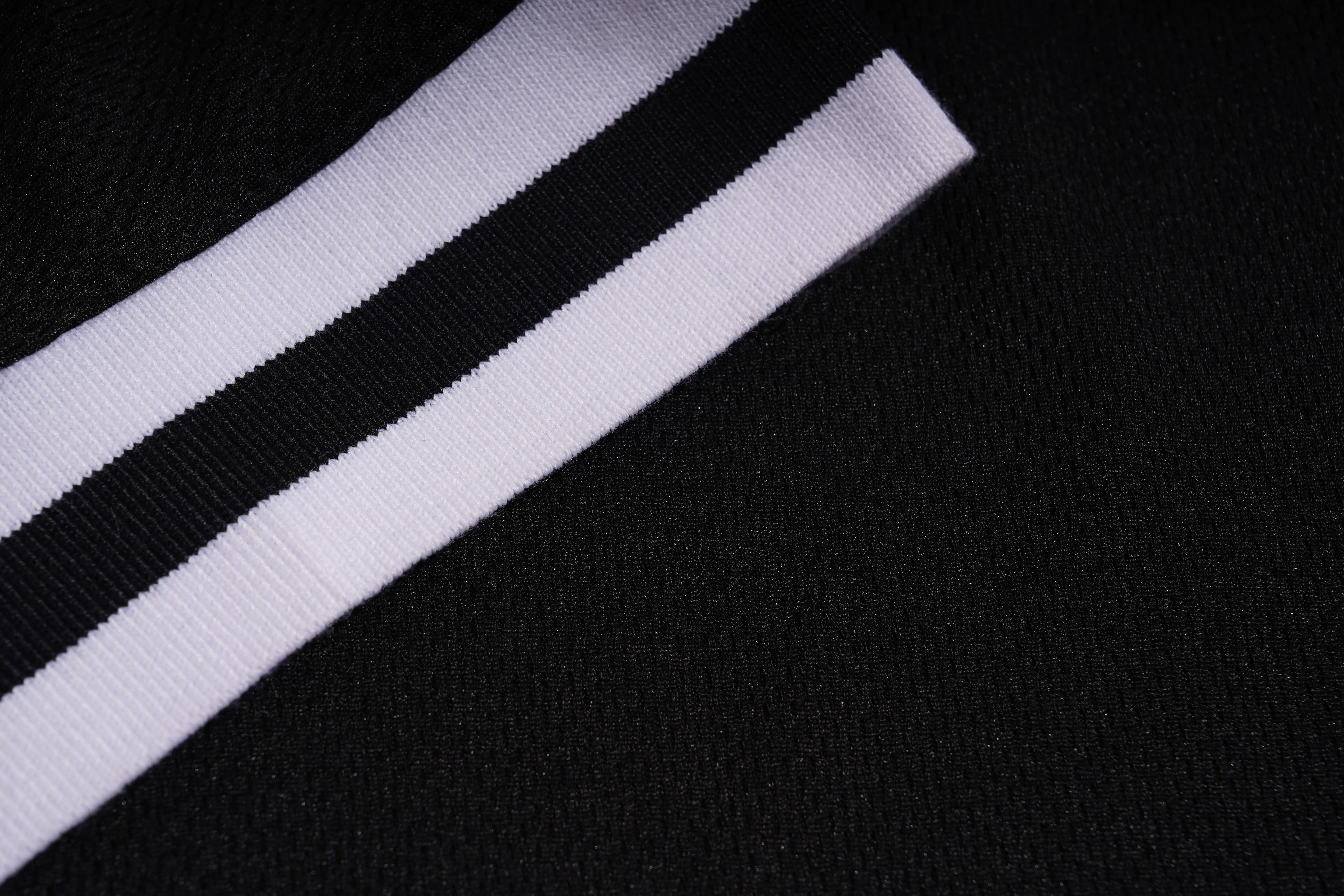 Close-up of a black and white striped fabric on a dark background, TCH Angel Wings Rhinestone V-Neck Tee