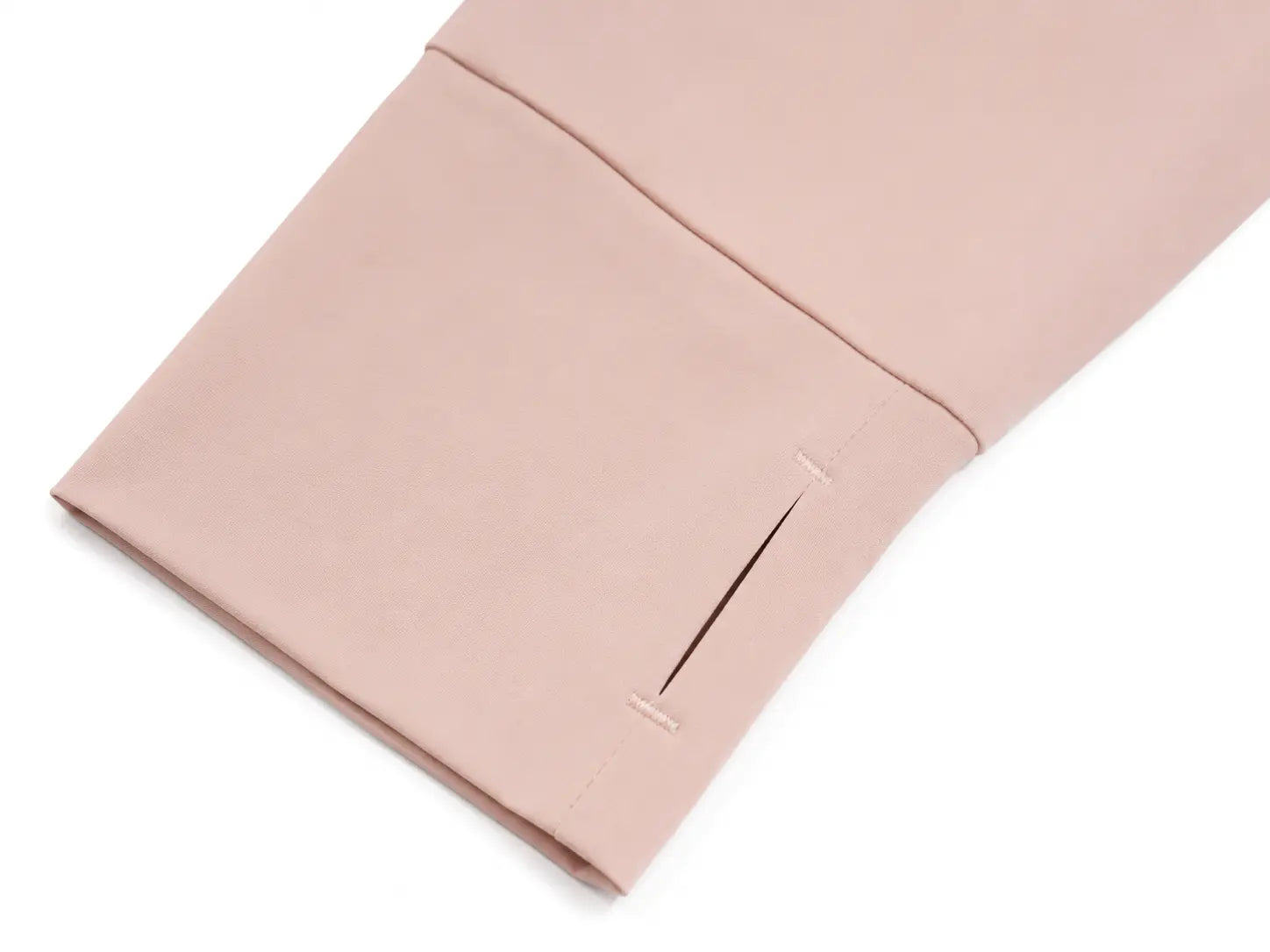 A close-up of a dusty pink fabric sleeve or cuff with a diagonal seam and a single vertical slit, shown on a plain white background. TCH Angel Wings Rhinestone Zip-Up Hoodie