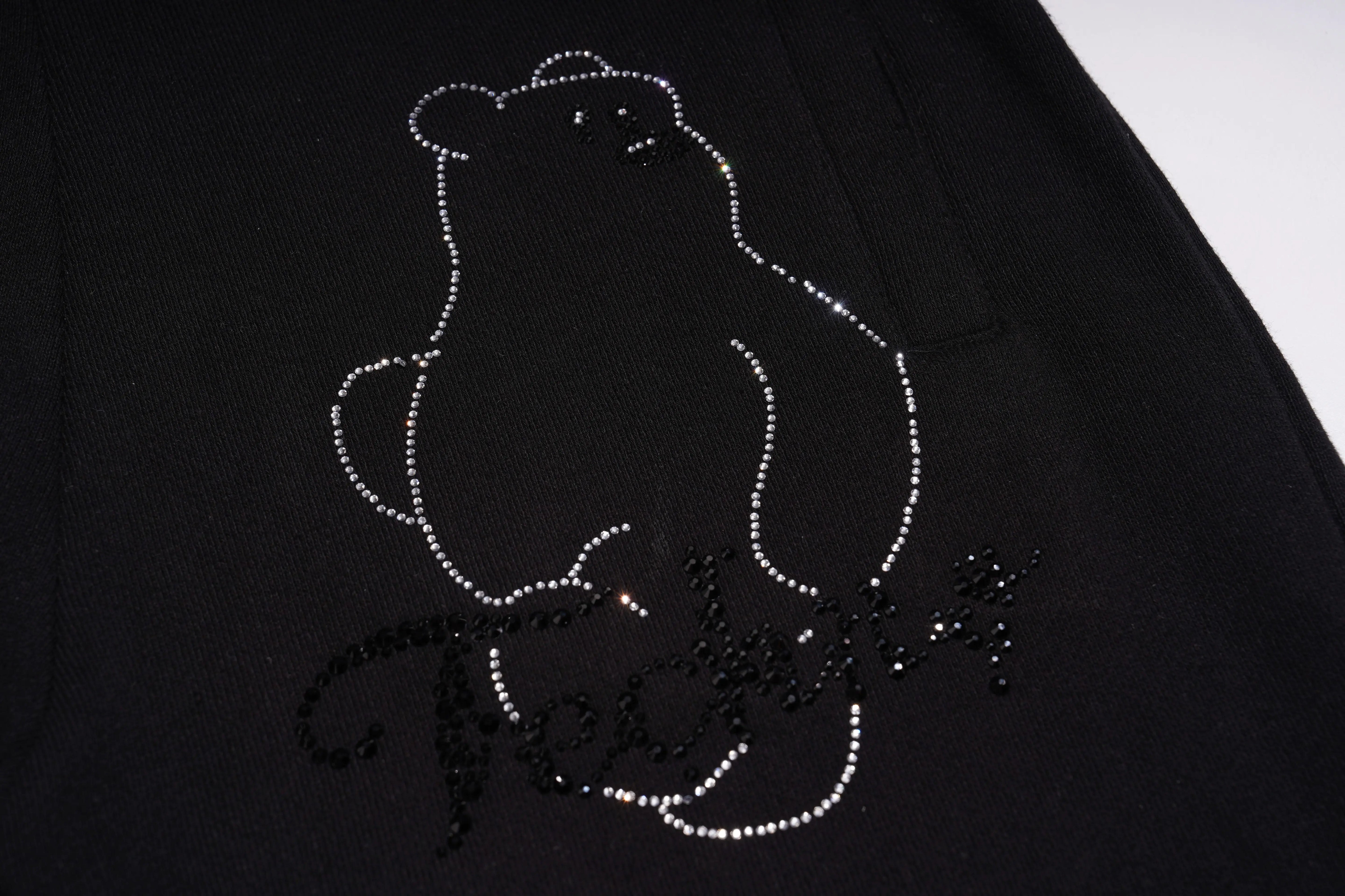 Black fabric with a white bear design made of small stones or beads. TCH Bear Sketch Rhinestone Jogger Pants