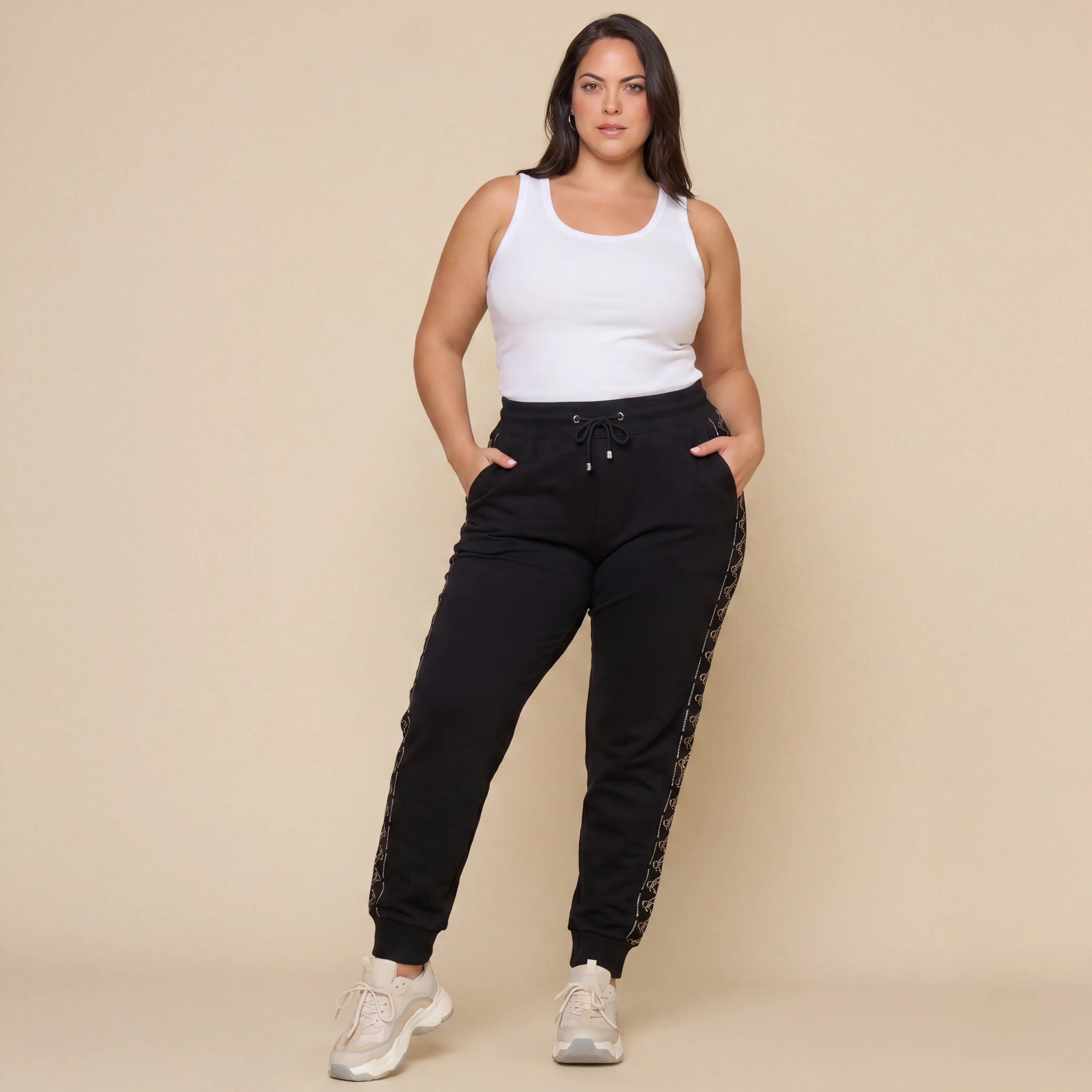 Woman wearing a white tank top and black jogger pants with a beige background, TCH Black Rhinestone Side Stripe Jogger Pants