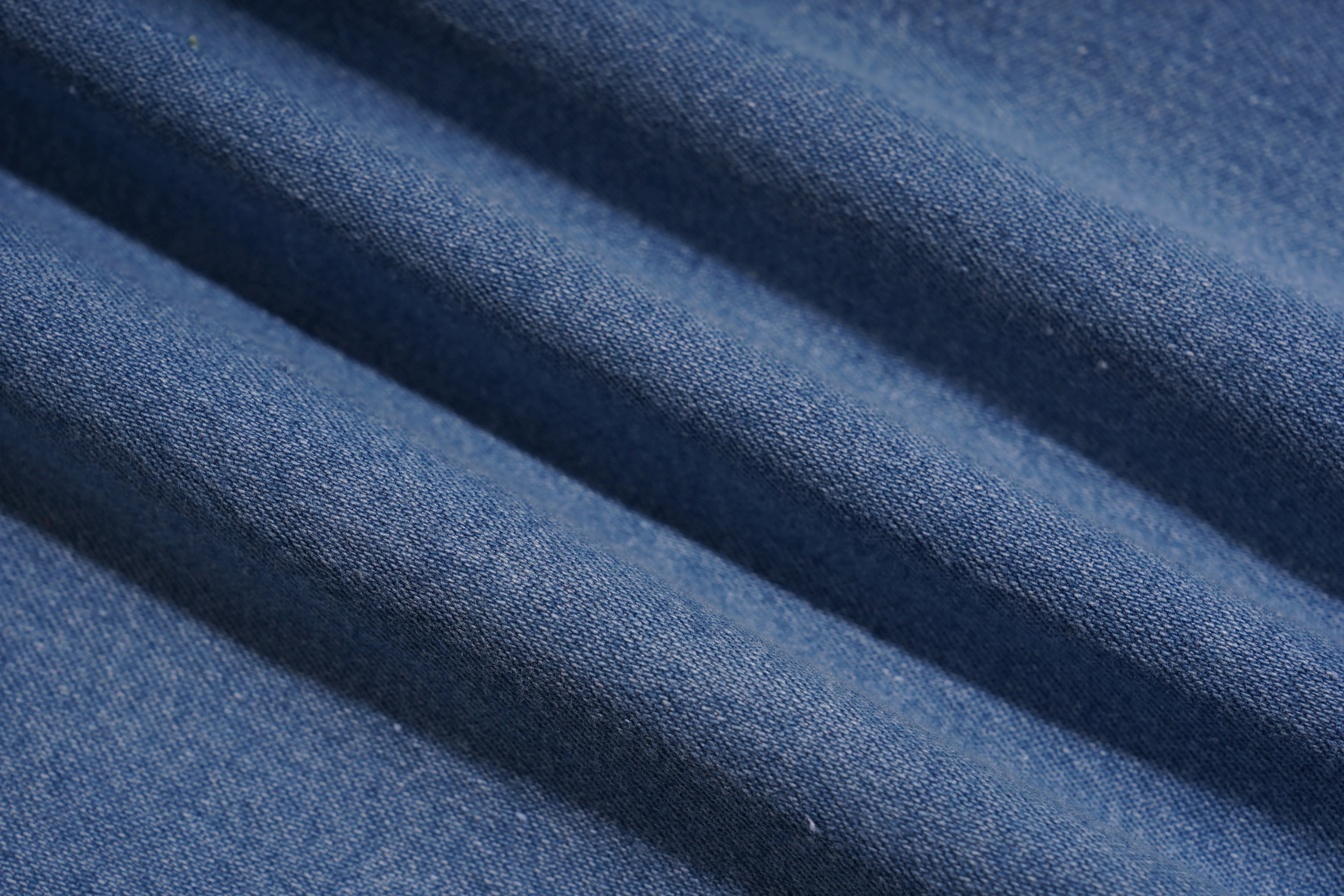 A close-up of blue woven fabric with soft diagonal folds showing the textile texture. TCH Blue Butterfly & Teddy Bear Lace Hem Denim Jeans