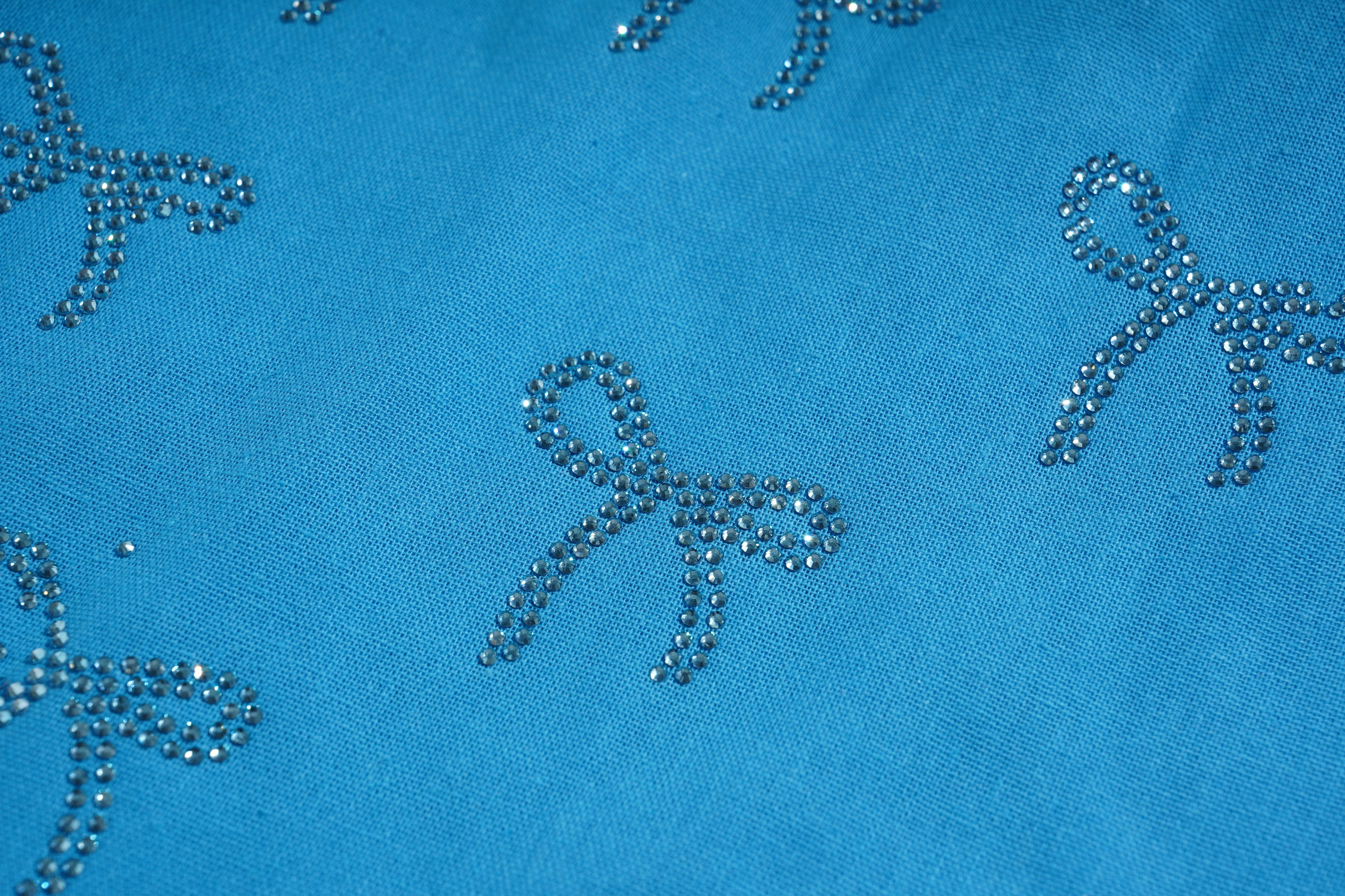 Blue fabric with decorative bow patterns made of small beads or stones. TCH Blue Rhinestone Bow Matching Set