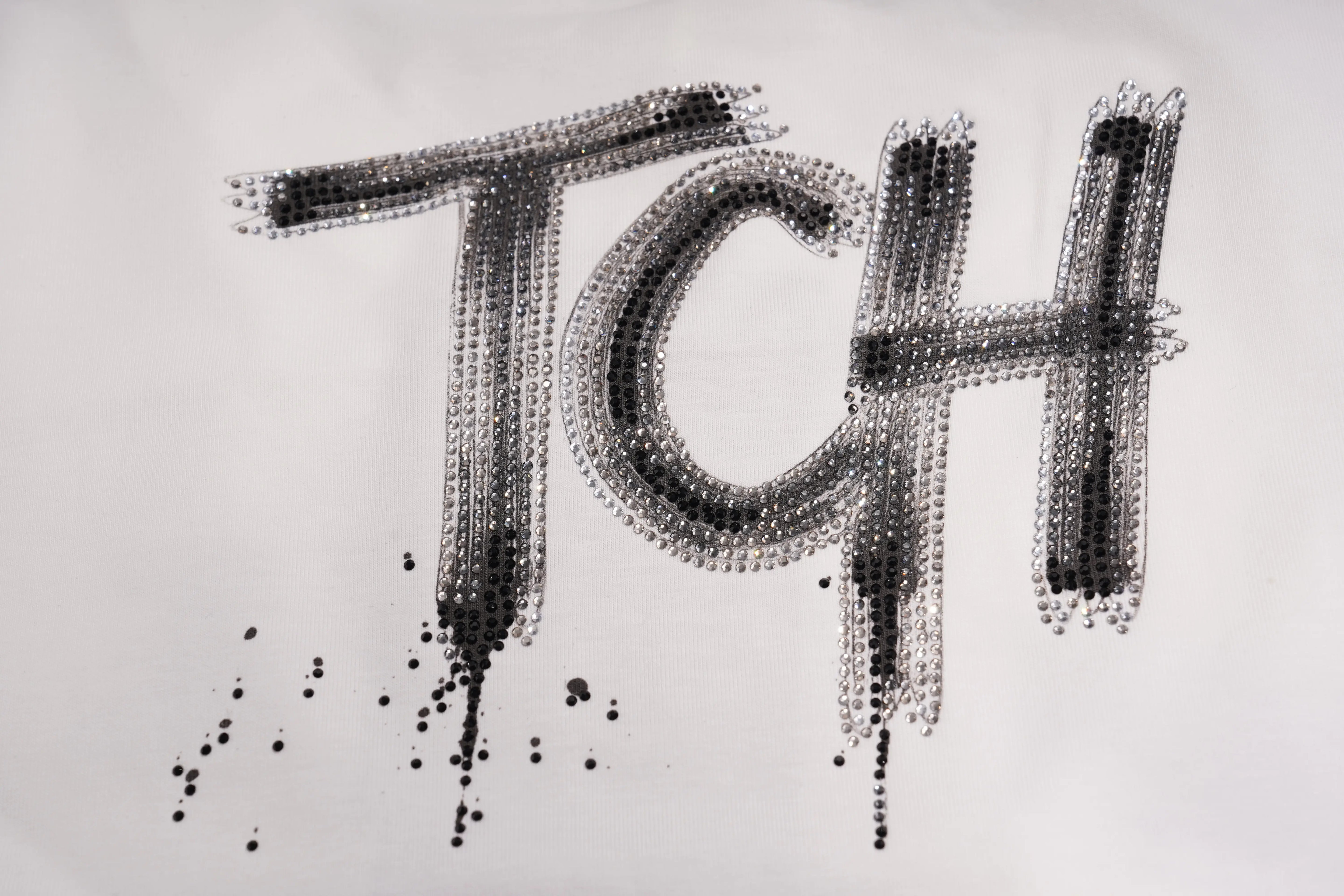 Black and silver beaded lettering spelling 'TCH' with dripping paint effects on a white background. TCH Brush Logo Graphic Oversized T-Shirt