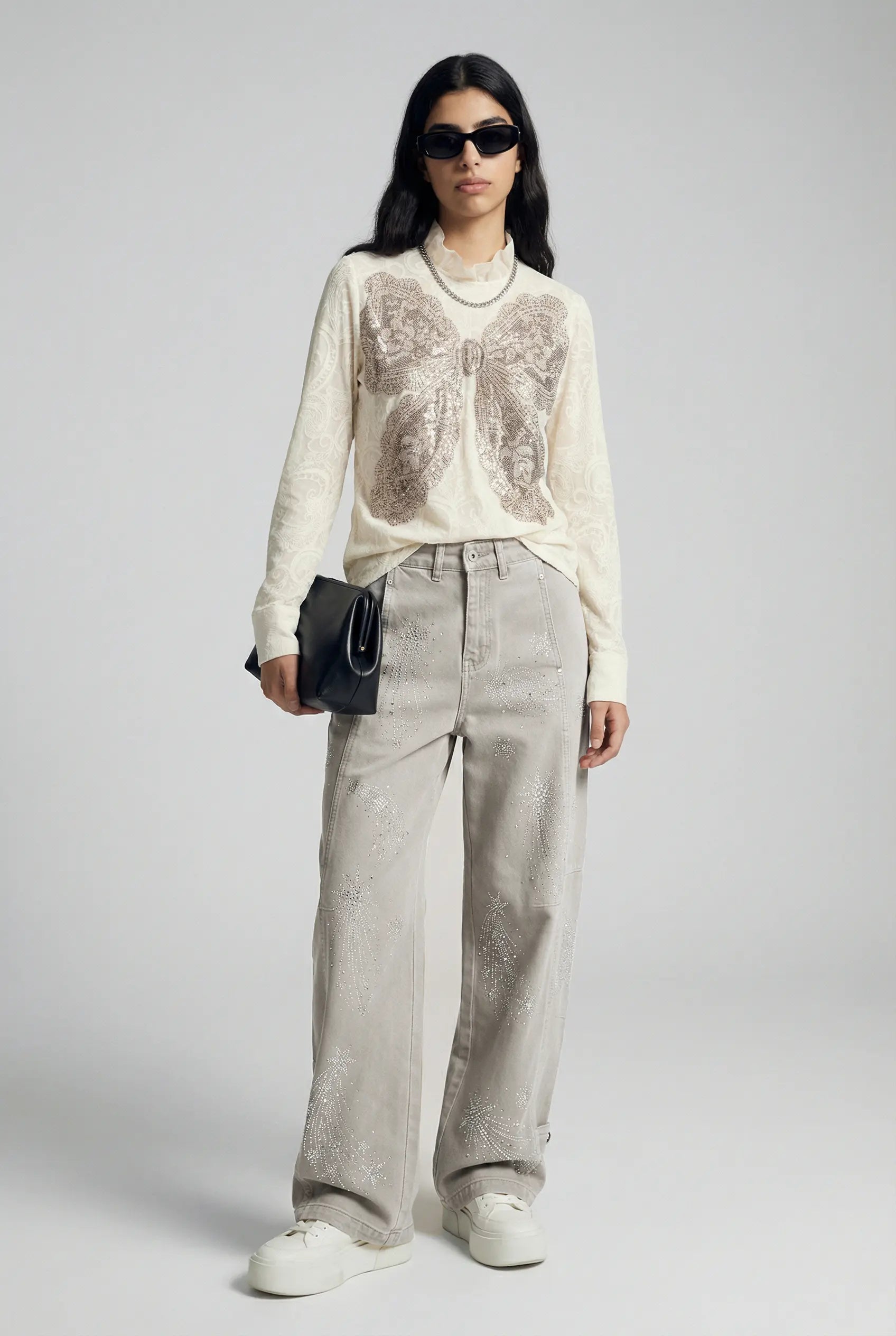 Woman wearing a white blouse with a pattern, light gray pants, and white sneakers on a plain background, TCH Celestial Firework Rhinestone Wide-Leg Pants