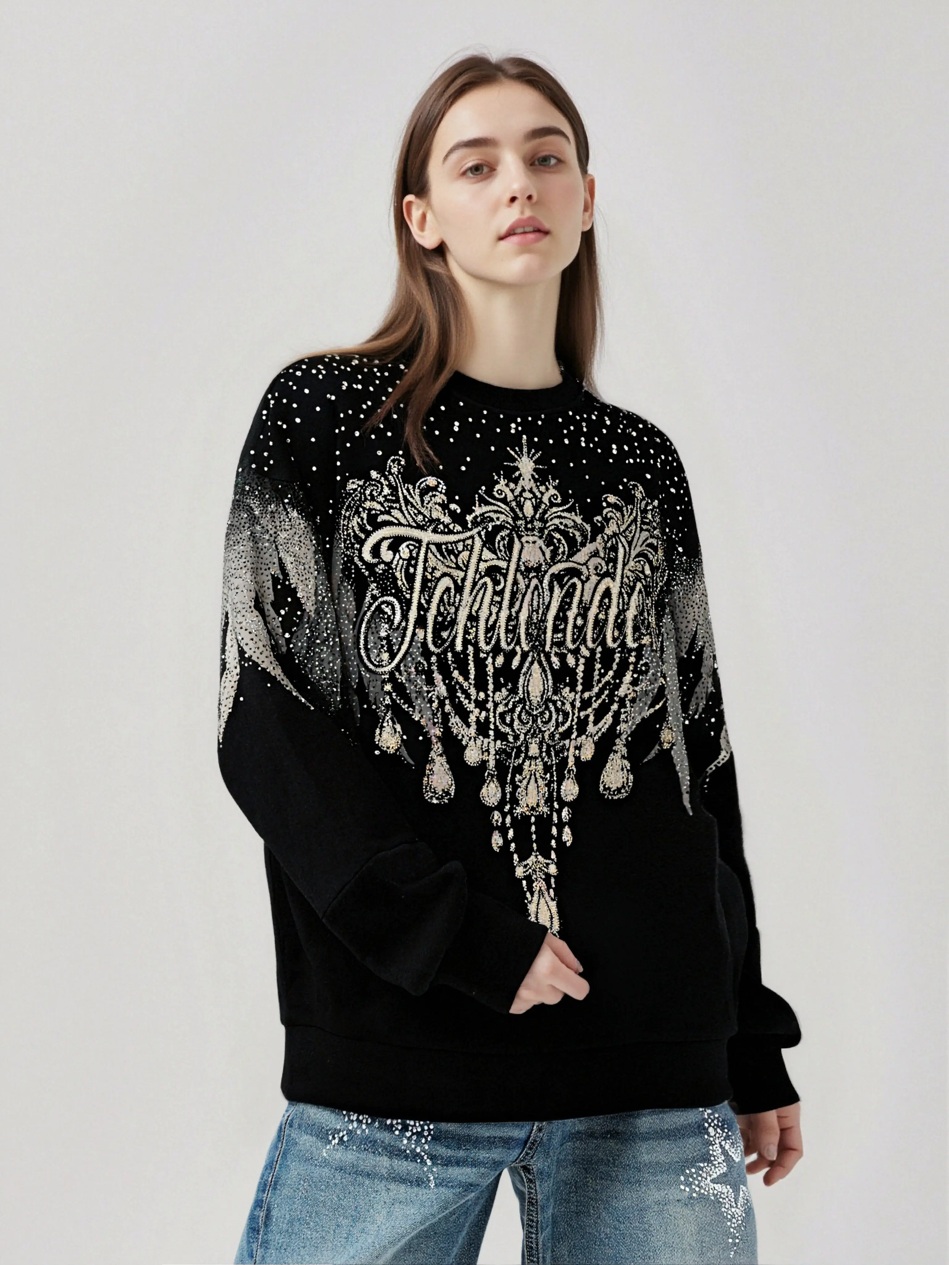 Person wearing a black sweater with decorative text and patterns on a plain background, TCH Celestial Wing Graphic Crewneck Sweatshirt