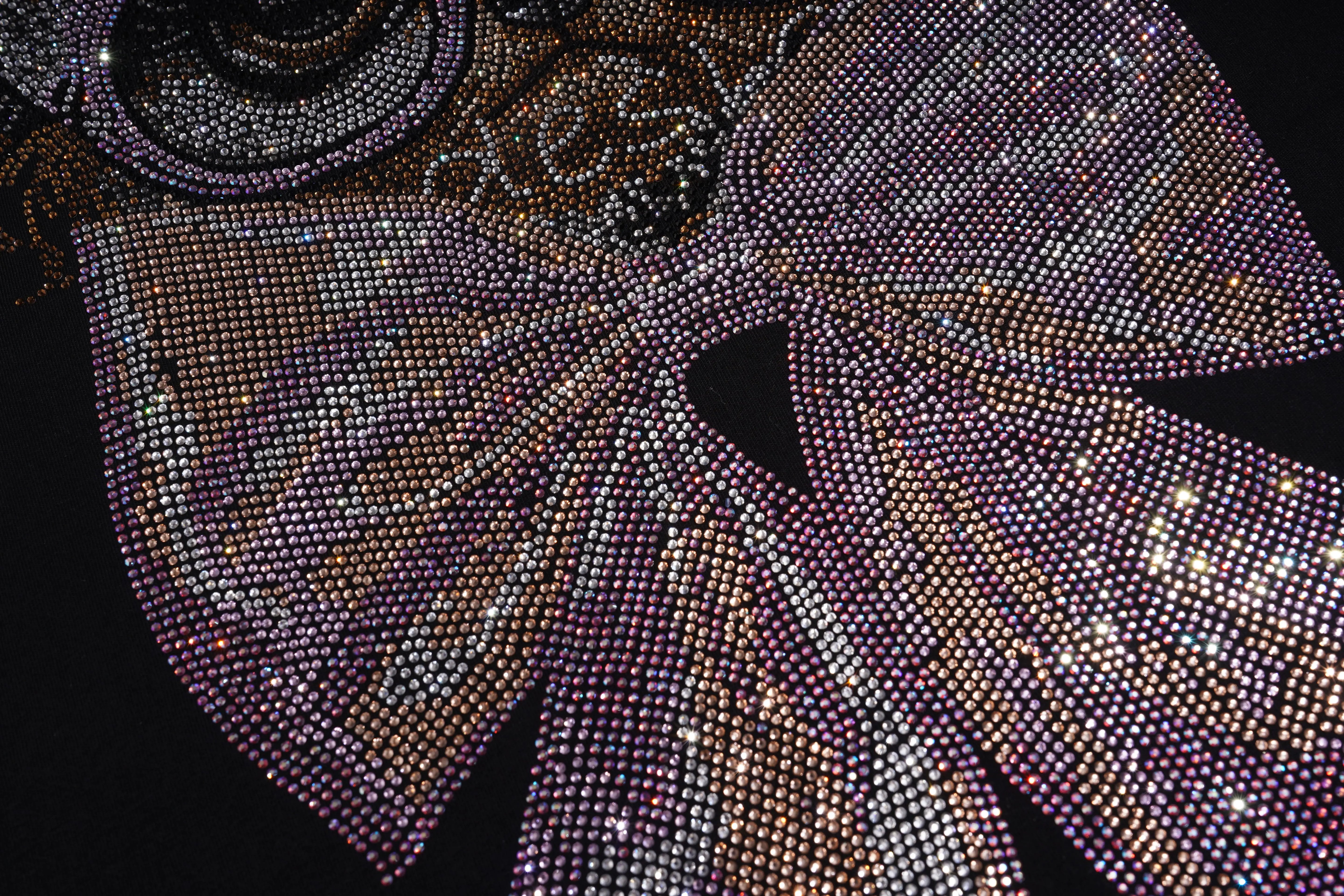 Close-up of a sparkling, decorative fabric with intricate patterns on a black background, TCH Chihuahua Bow Rhinestone T-Shirt