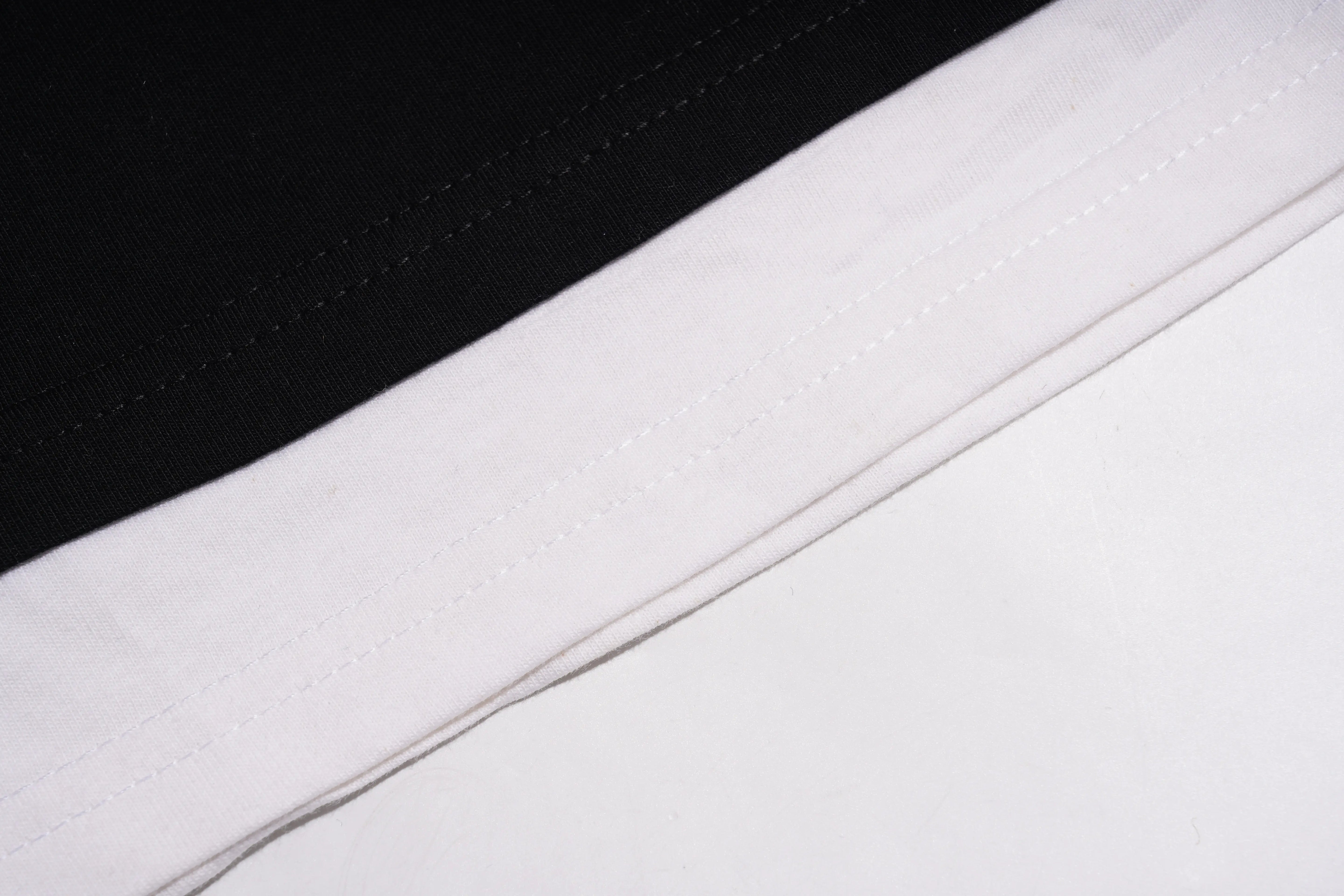 Close-up of black and white fabric with a visible seam. TCH Chihuahua Bow Rhinestone T-Shirt