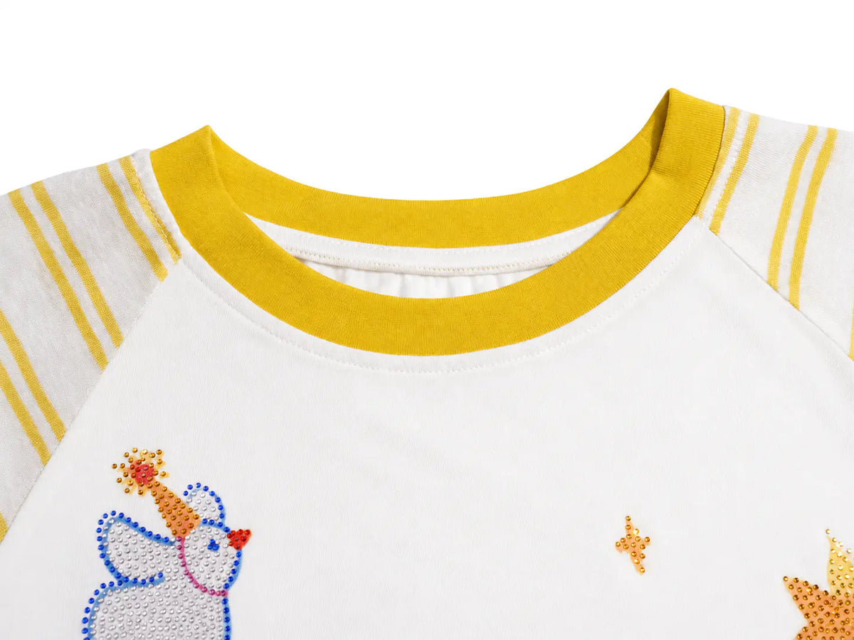 Close-up of a white raglan baseball-style shirt with a yellow ribbed crew neck, yellow stripes on the sleeves, and embroidered details including a blue and yellow penguin and gold stars. TCH Cute Bunny Rhinestone Graphic Striped Sleeve Long Sleeve T-Shirt