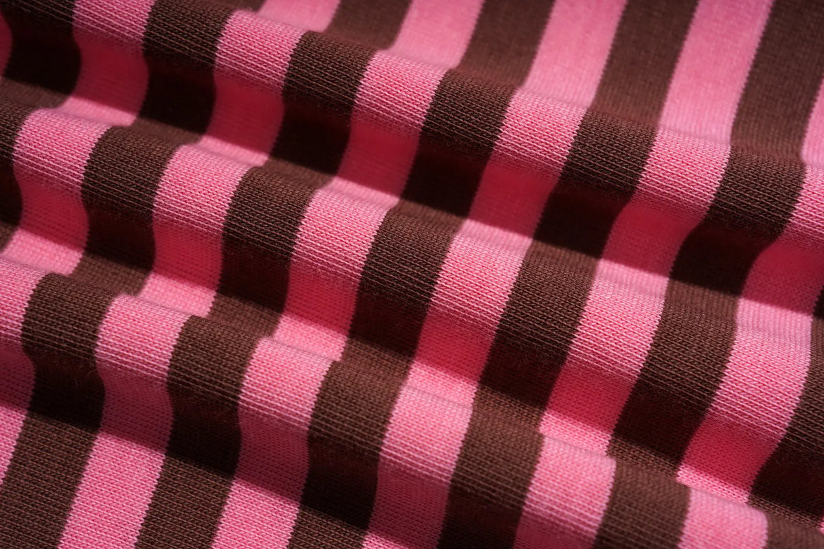 A close-up of a knitted fabric with alternating vertical stripes in bright pink and dark brown. TCH Cute Lamb Pink Striped Raglan Long Sleeve Top