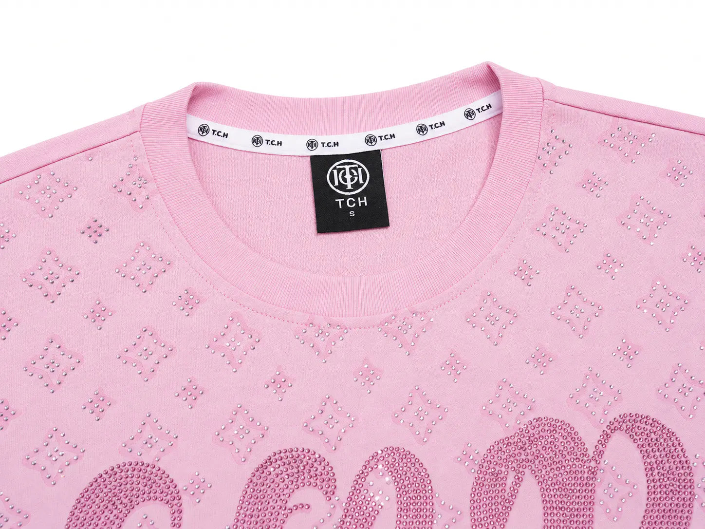 Close-up of a light pink crewneck sweatshirt featuring an all-over rhinestone monogram pattern and a large matching monogram across the chest, with a black TCH neck label visible. TCH Cute Teddy Bear Rhinestone Oversized T-Shirt Dress