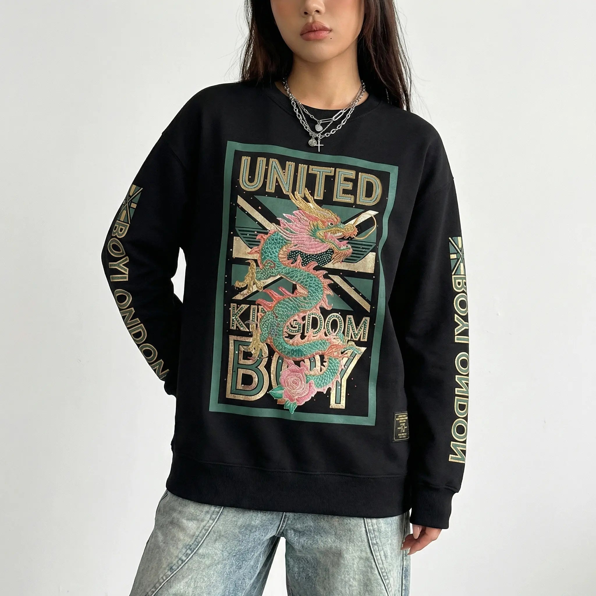 Black sweatshirt with dragon design and text worn by a person on a white background. TCH Dragon Embroidered Rhinestone Sweatshirt