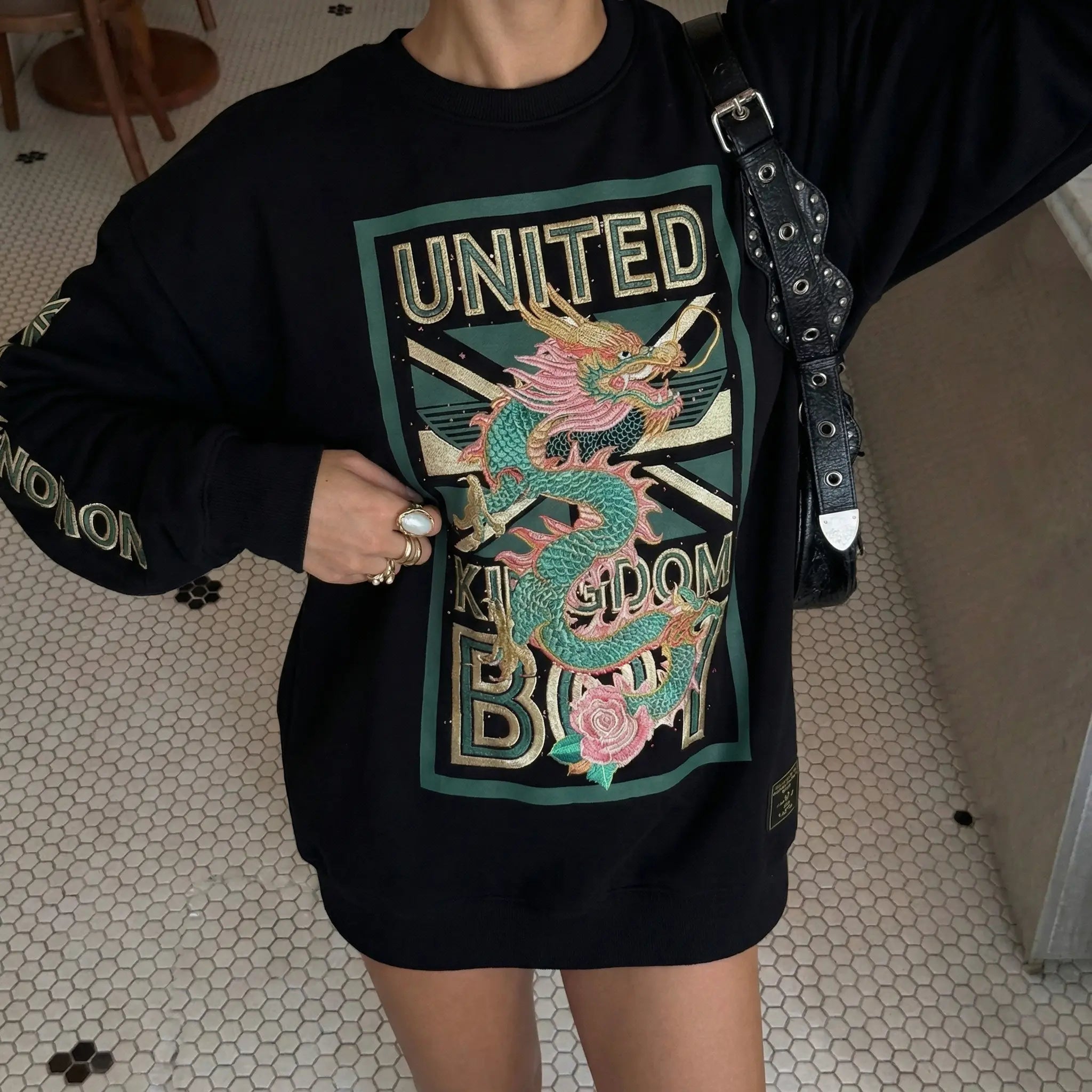 Person wearing a black sweatshirt with a colorful dragon design and 'UNITED KINGDOM BOY' text. TCH Dragon Embroidered Rhinestone Sweatshirt-