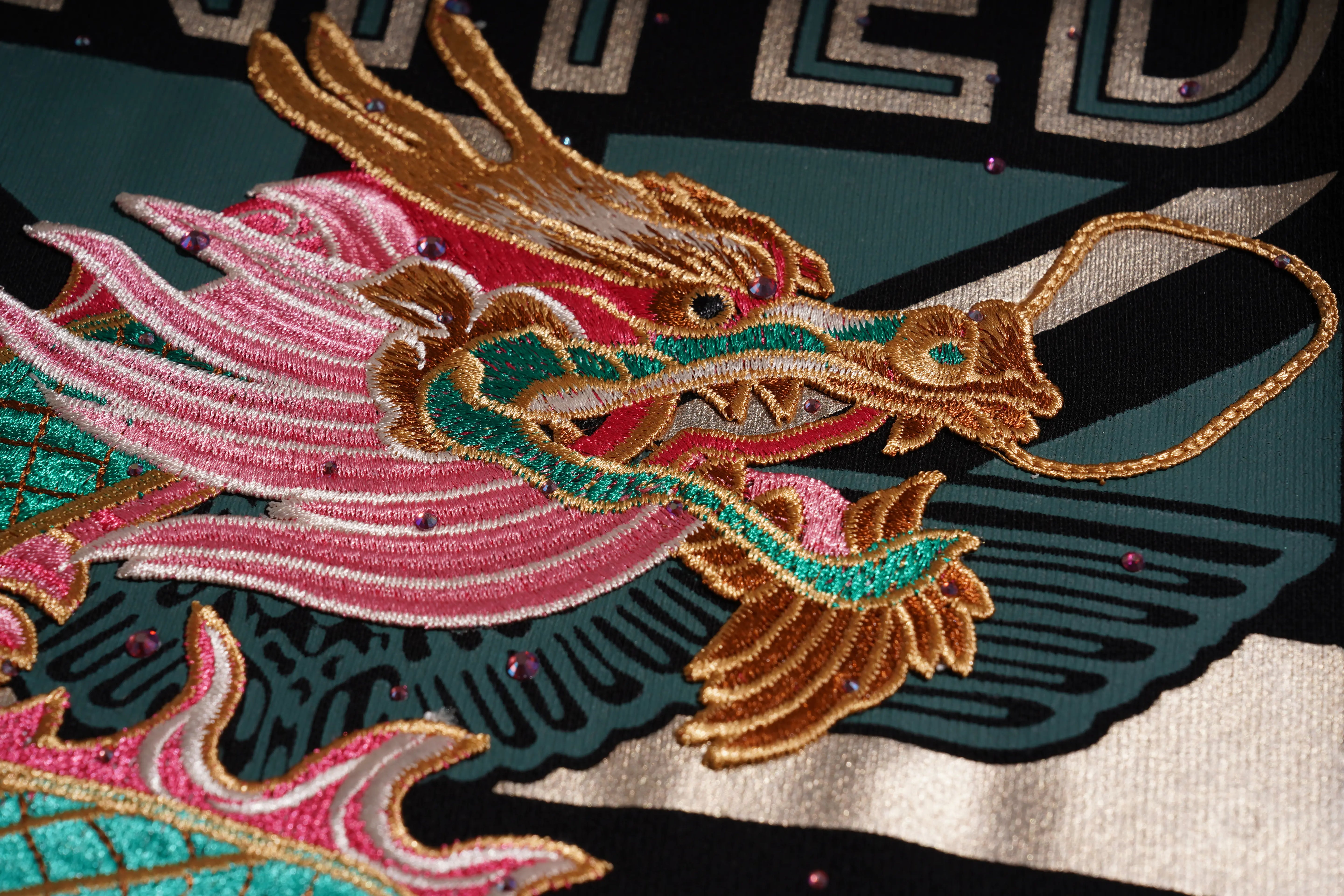 Colorful embroidered dragon design on fabric with visible brand name. TCH Dragon Embroidered Rhinestone Sweatshirt-