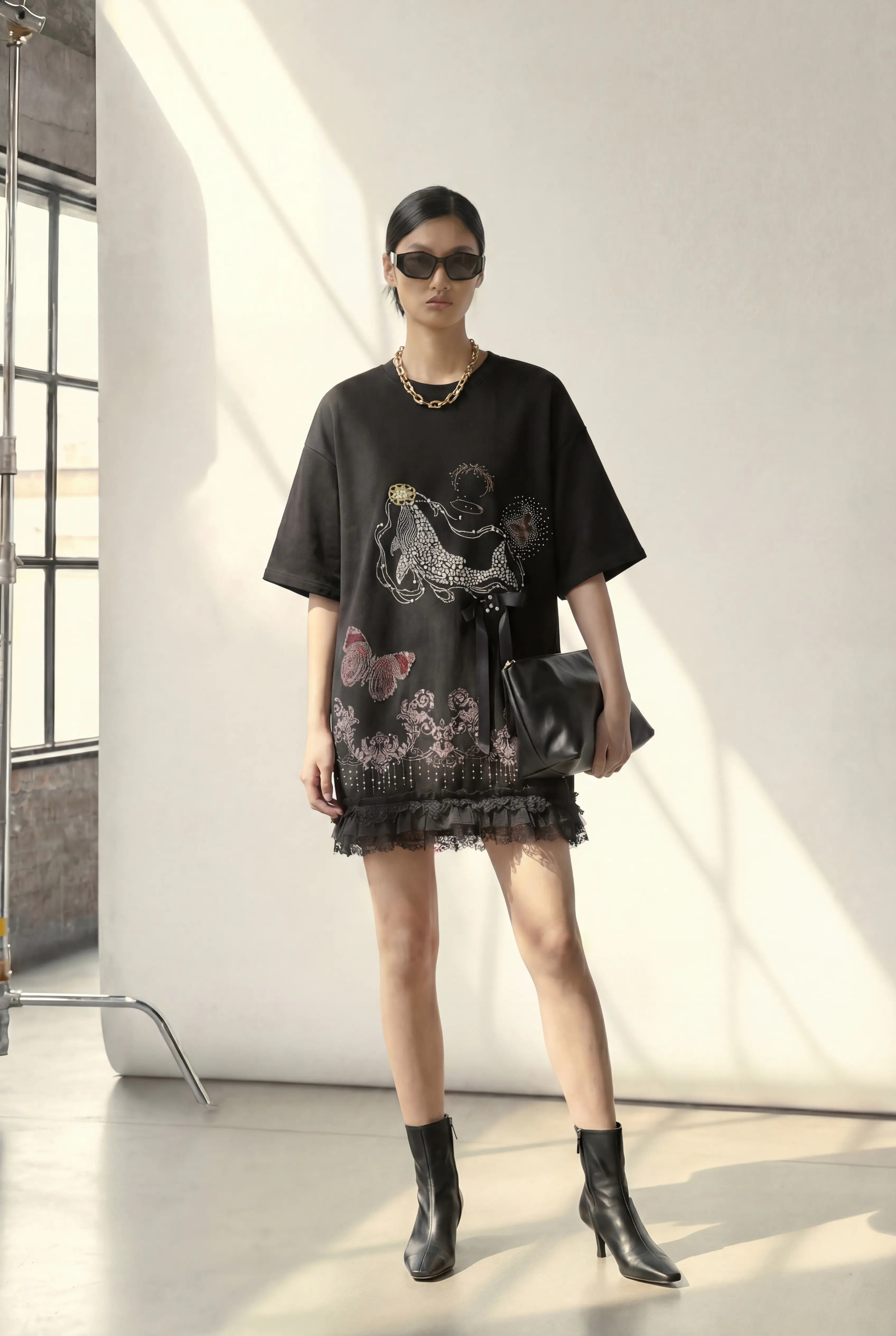 Woman wearing a black outfit with floral patterns in a minimalistic setting, TCH Dream Whale Rhinestone Lace Midi Dress