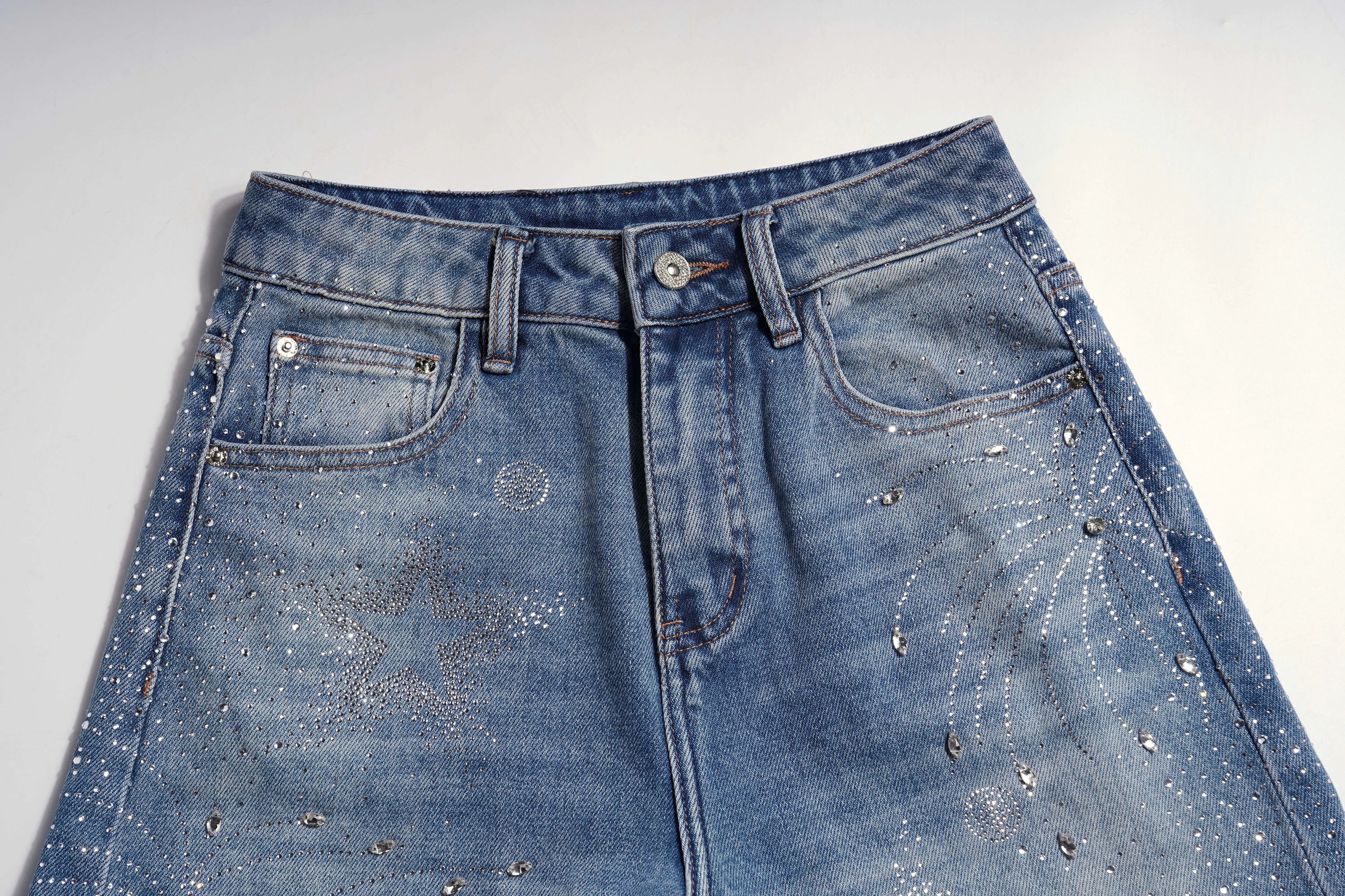 Close-up of a blue denim skirt with distressing details on a white background, TCH Firework Star Rhinestone Straight-Leg Blue Jeans
