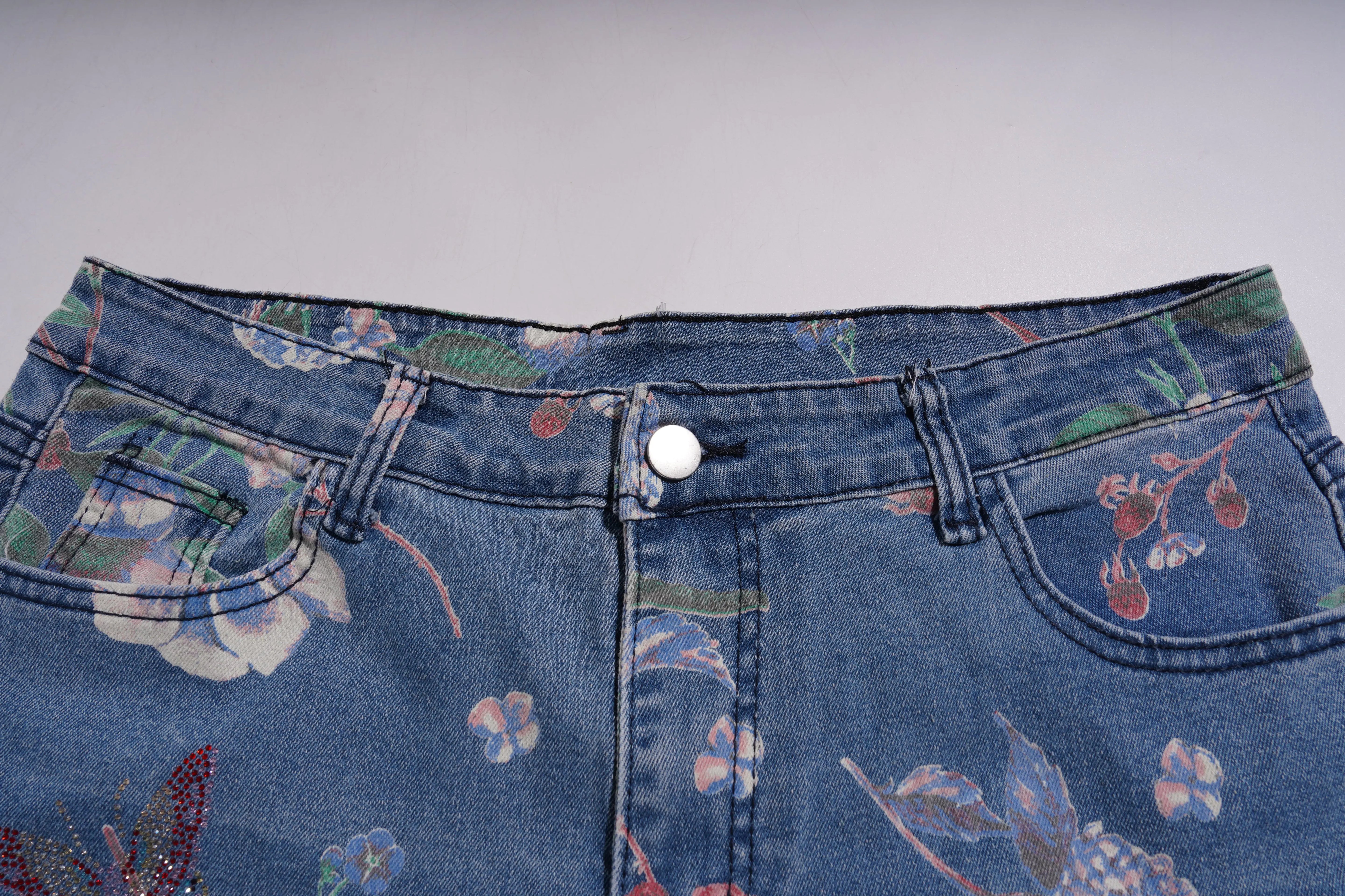 Close-up of blue jeans with floral patterns on a gray background, TCH Floral Print Rhinestone Butterfly Denim Jeans
