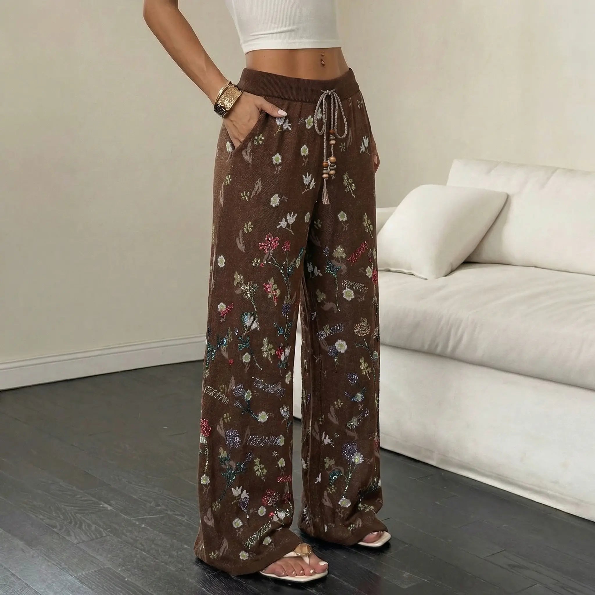 Person wearing brown floral pants in a living room setting, TCH Floral Rhinestone Accent Sweatpants