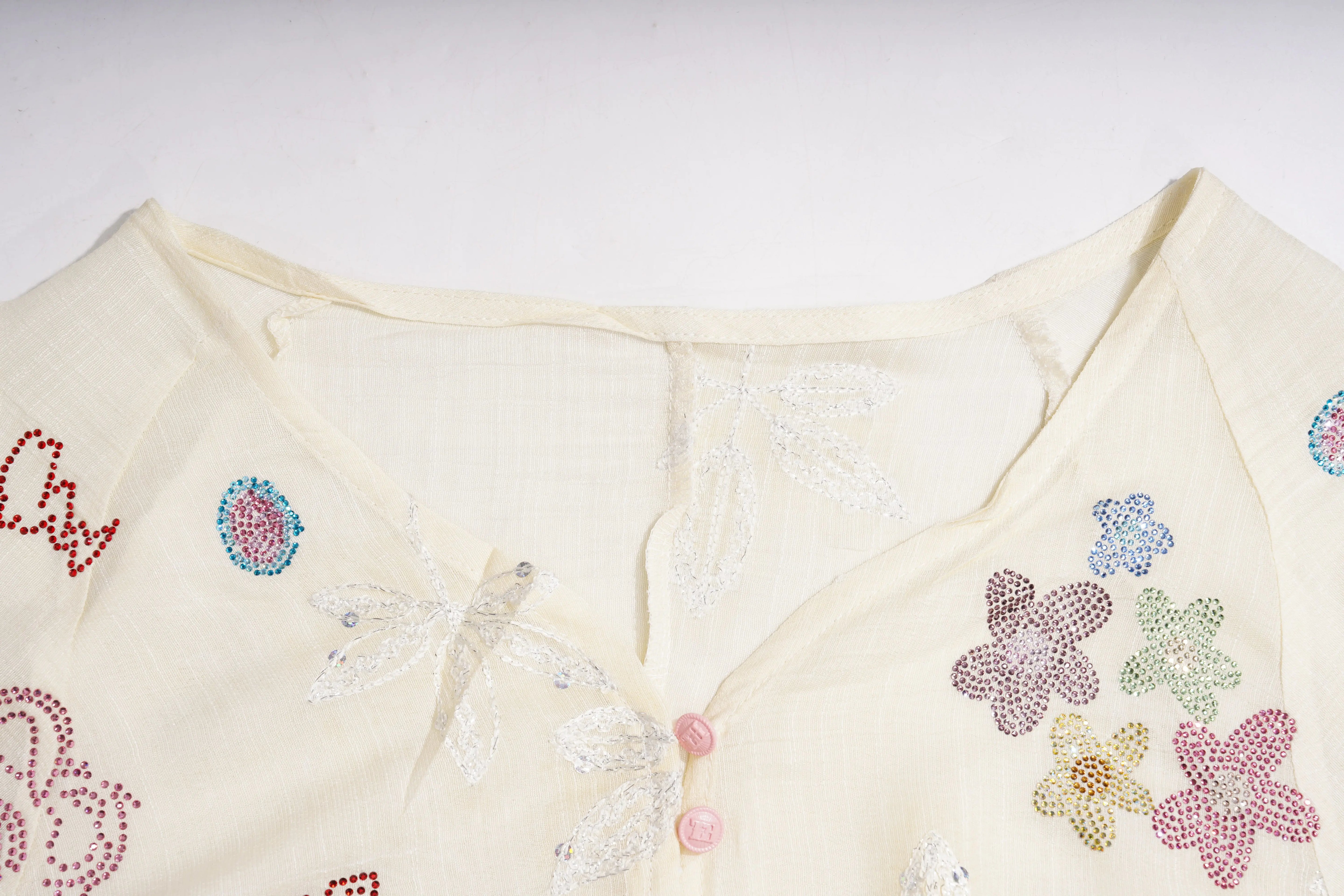 White garment with colorful floral embellishments on a white background, TCH Floral Rhinestone Embellished V-Neck Blouse