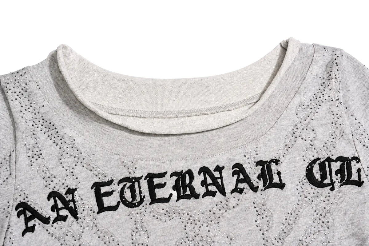 Close-up of a light gray heather t-shirt featuring a textured, perforated pattern and the gothic-style text 'AN ETERNAL CH' printed in black across the chest. TCH Gothic Rhinestone Lace Pattern Flared Sleeve Long Sleeve Top