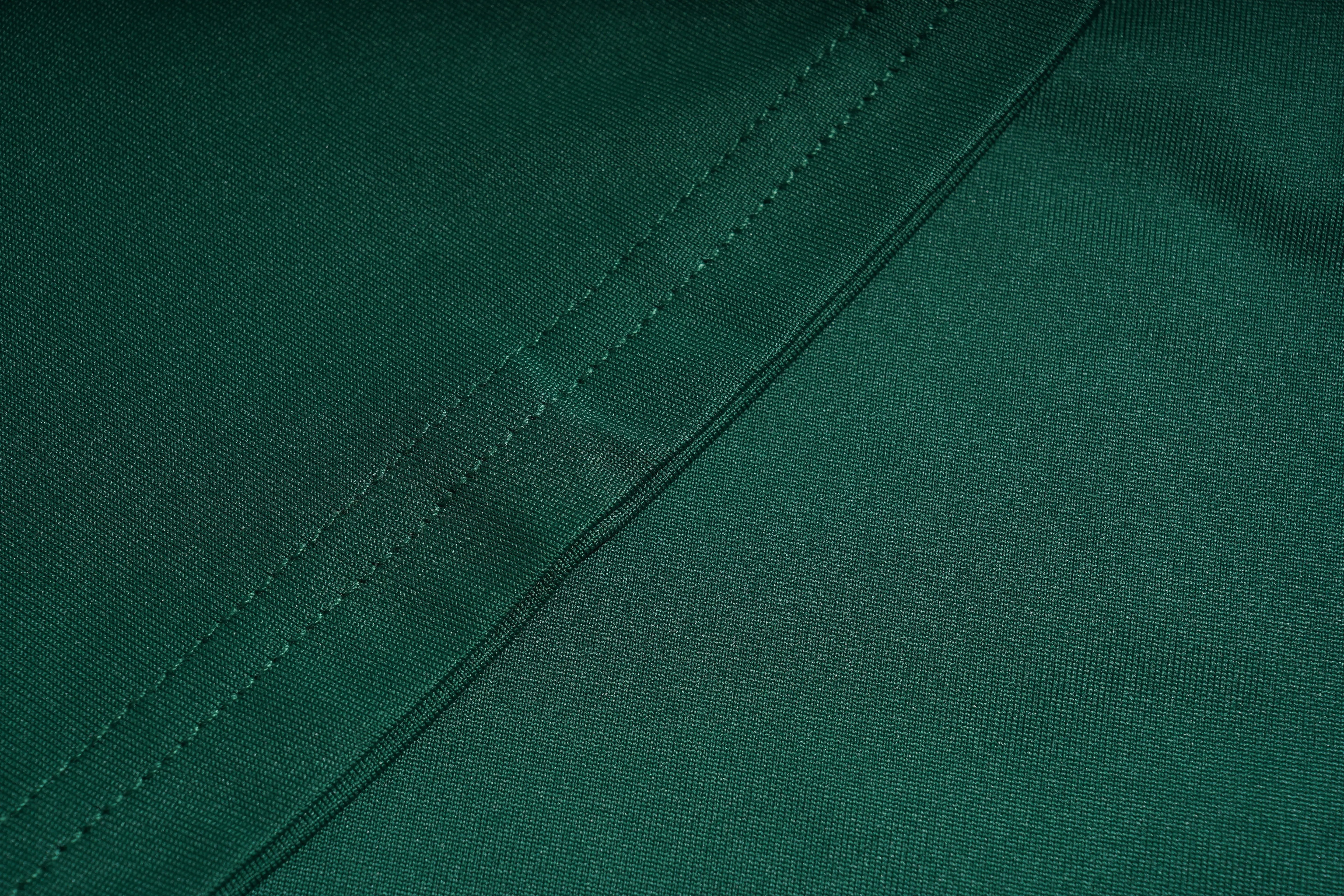Close-up of green fabric with stitching detail, TCH Green Lace Trim V-Neck Rhinestone Wing Long Sleeve Top