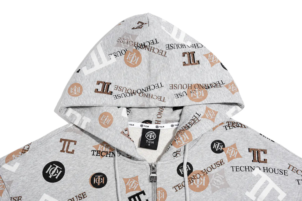 A light gray zip-up hoodie featuring an all-over 'Techno House' logo print in brown, black, and white, with a drawstring hood and a silver zipper. TCH Grey Logo Print Zip Hoodie