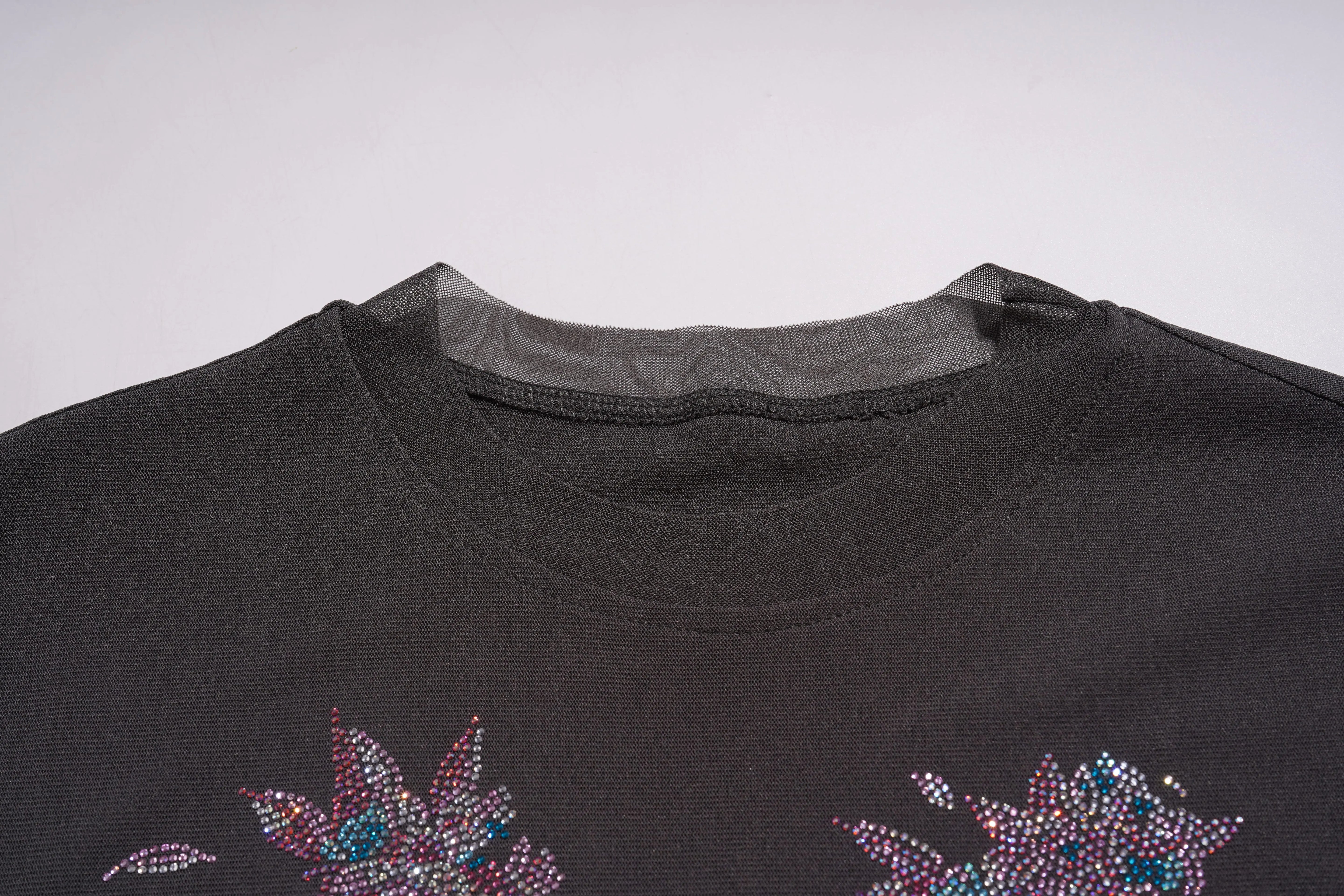 Close-up of a black garment with floral embellishments on a white background, TCH Grey Rhinestone Pink Wings Graphic T-Shirt