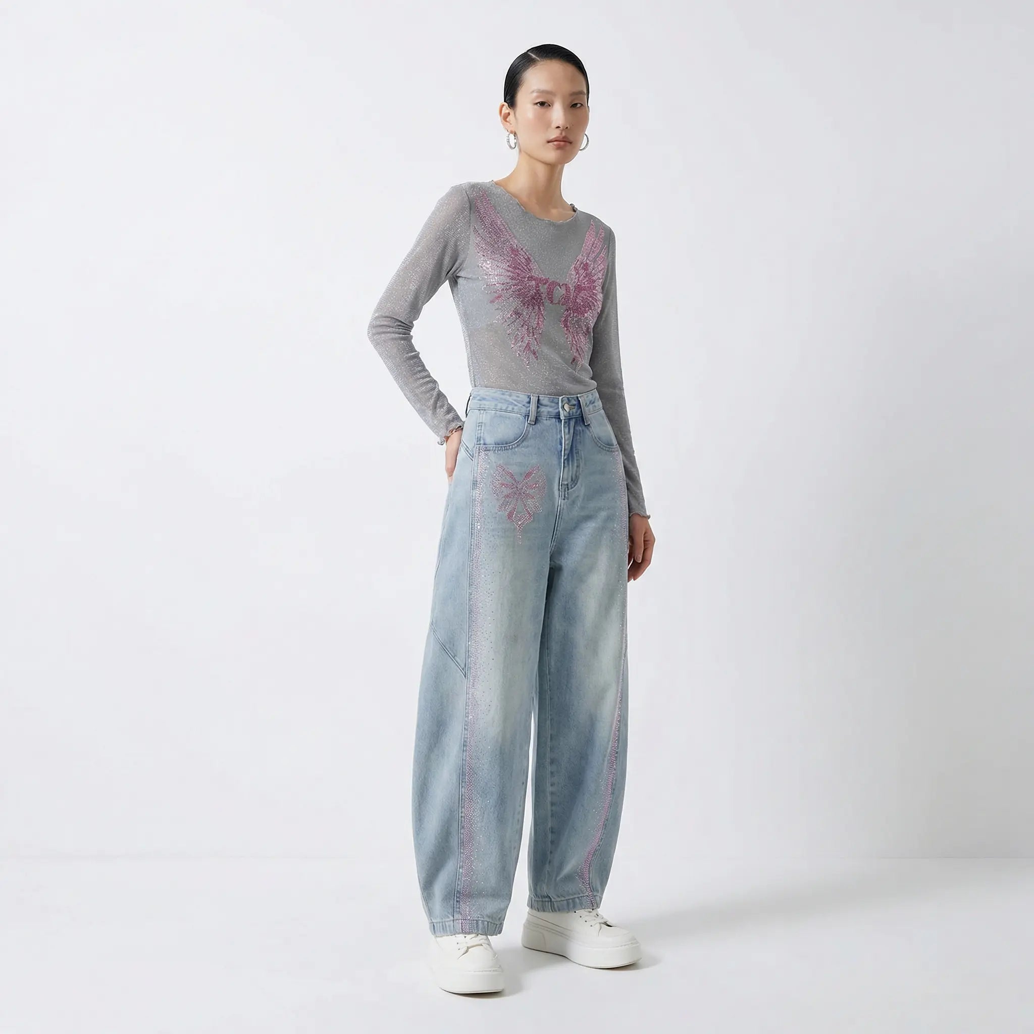 Woman wearing a gray long-sleeve top and light blue jeans with butterfly designs on a white background, TCH Grey Rhinestone Purple Wings Long Sleeve Top