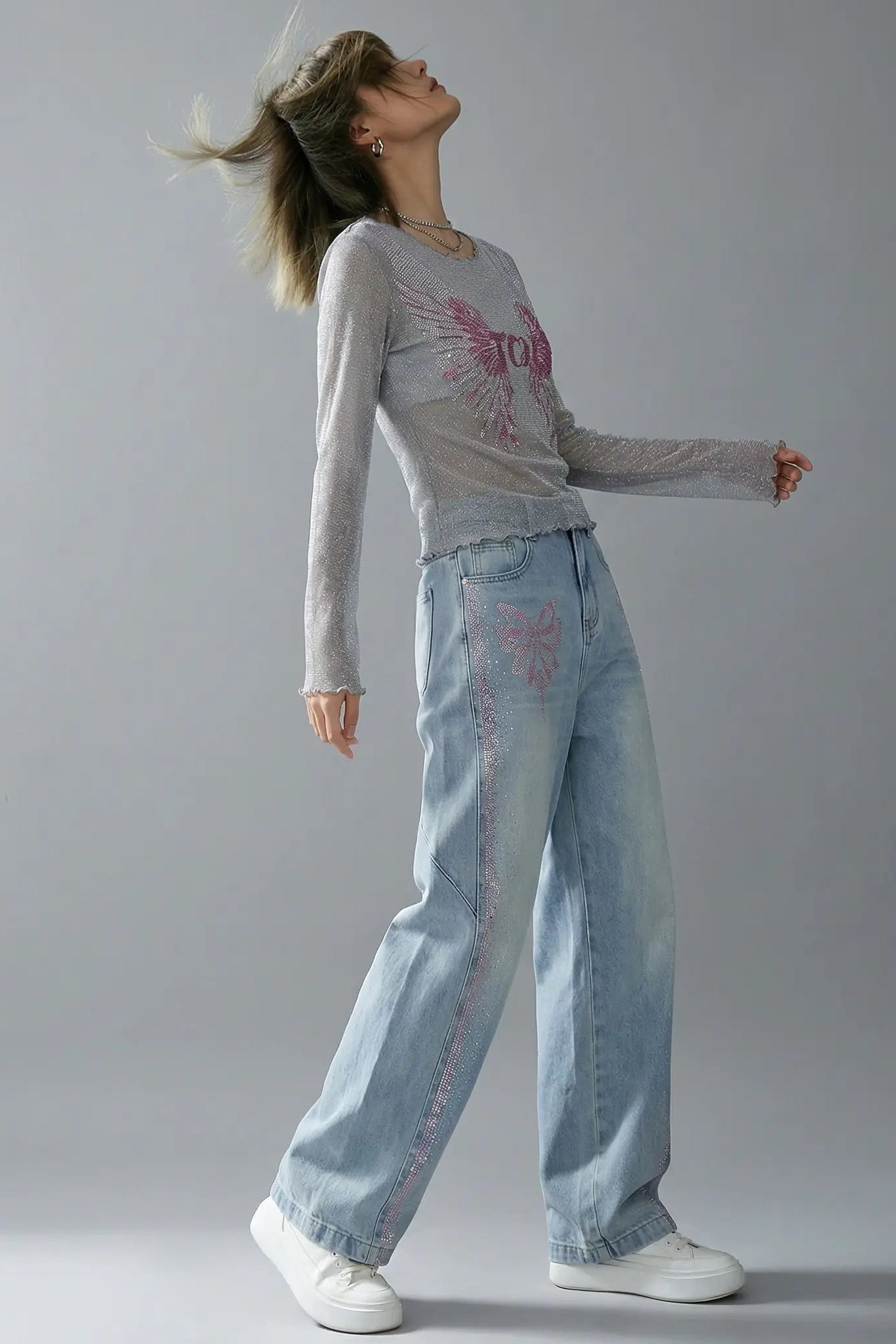 Person wearing a light gray long-sleeve shirt and blue jeans against a plain background, TCH Grey Rhinestone Purple Wings Long Sleeve Top