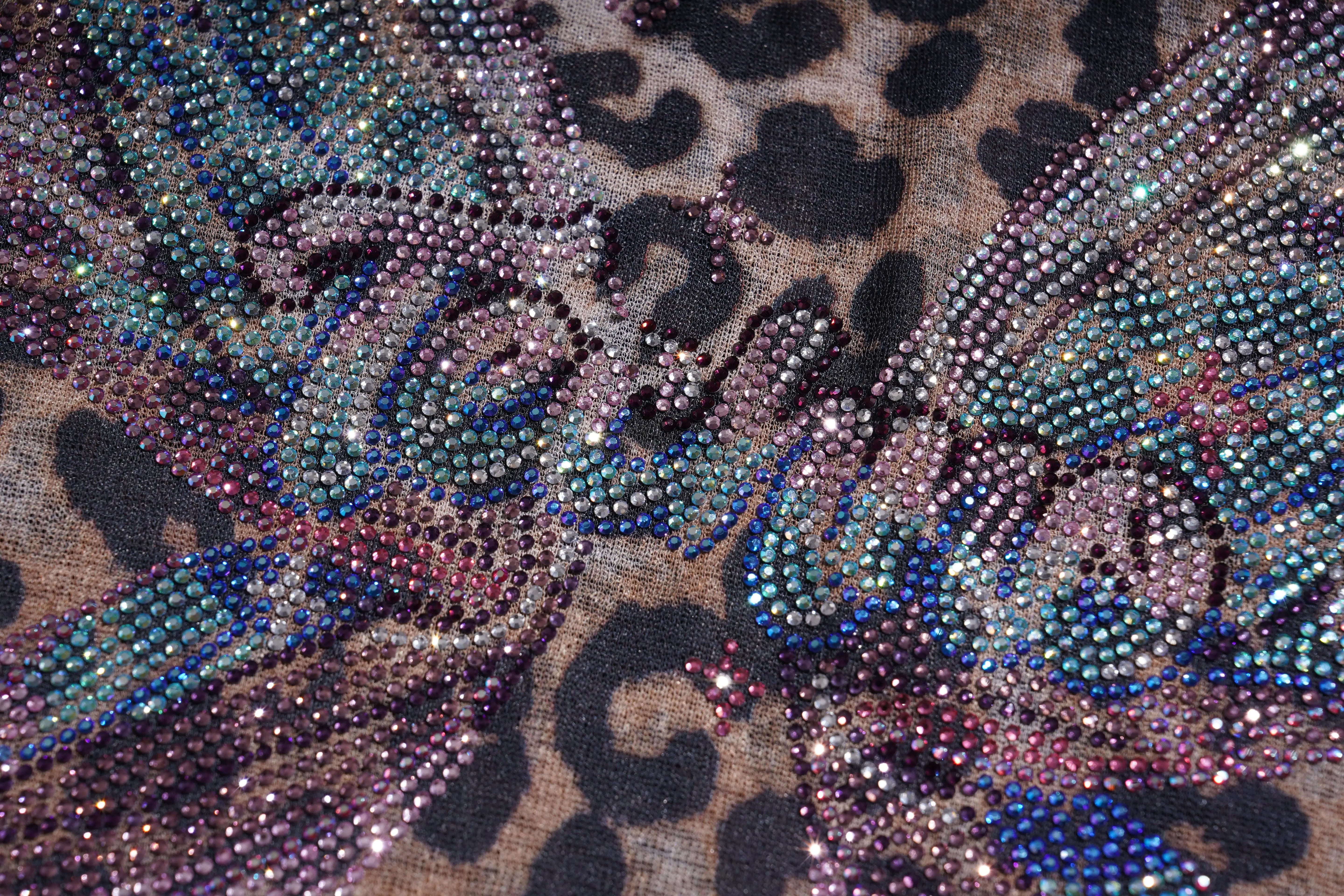 Close-up of a fabric with leopard print and decorative rhinestone patterns. TCH Leopard Print Rhinestone Butterfly Fitted T-Shirt