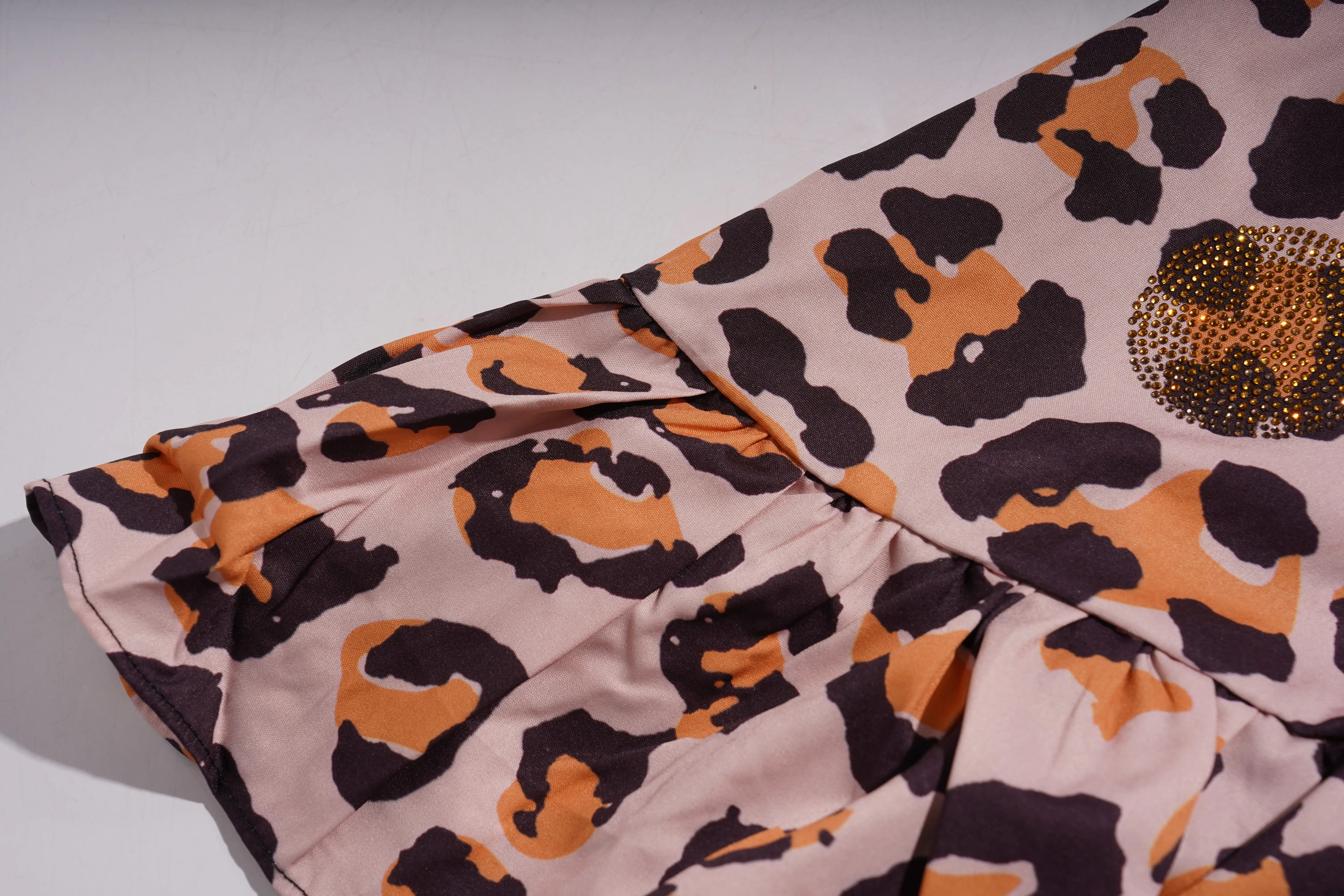 Leopard print fabric with a gold embellishment on a light background, TCH Leopard Rhinestone Animal Embellished Dress
