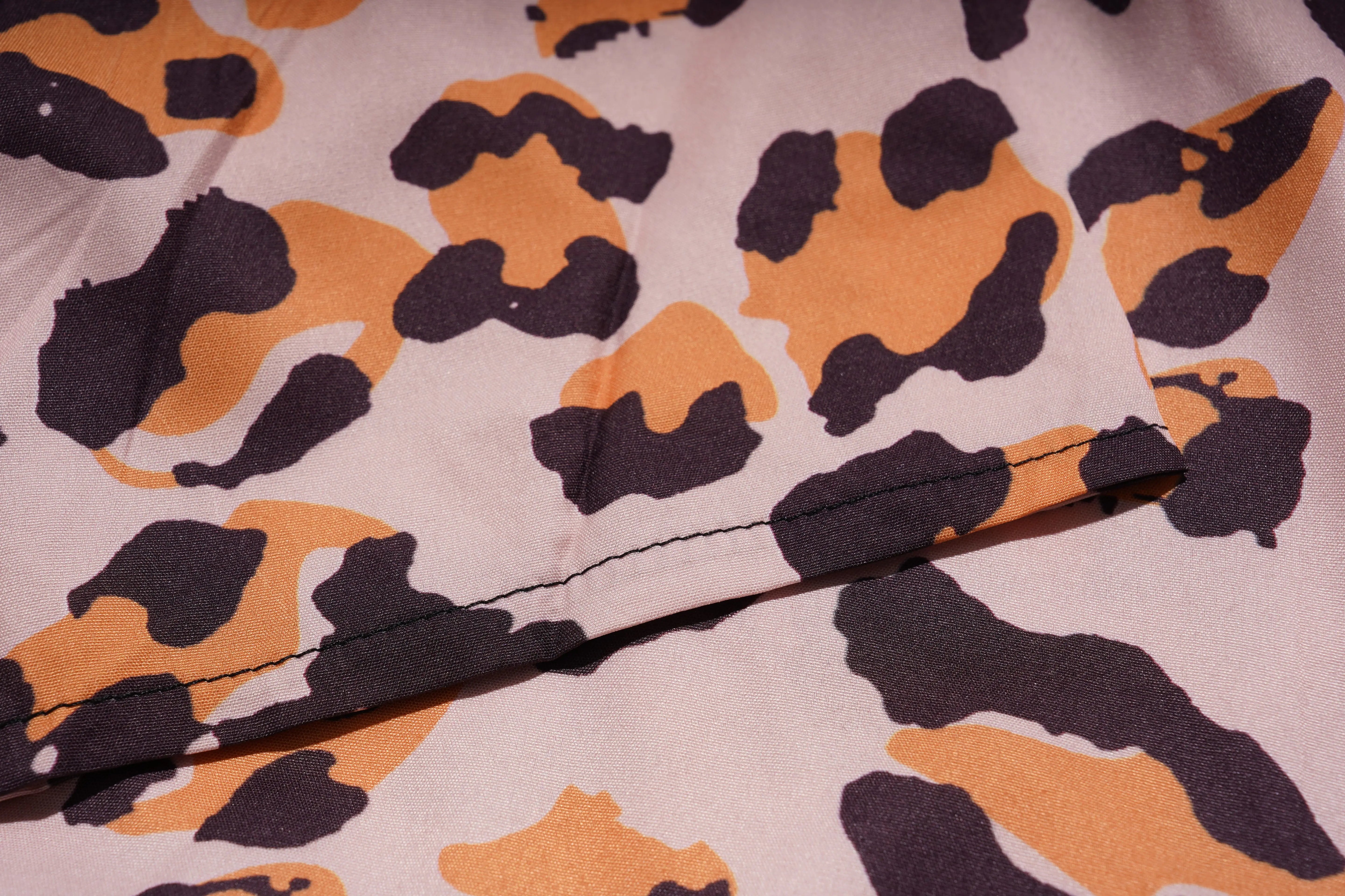 Close-up of fabric with a leopard print pattern on a beige background, TCH Leopard Rhinestone Animal Embellished Dress