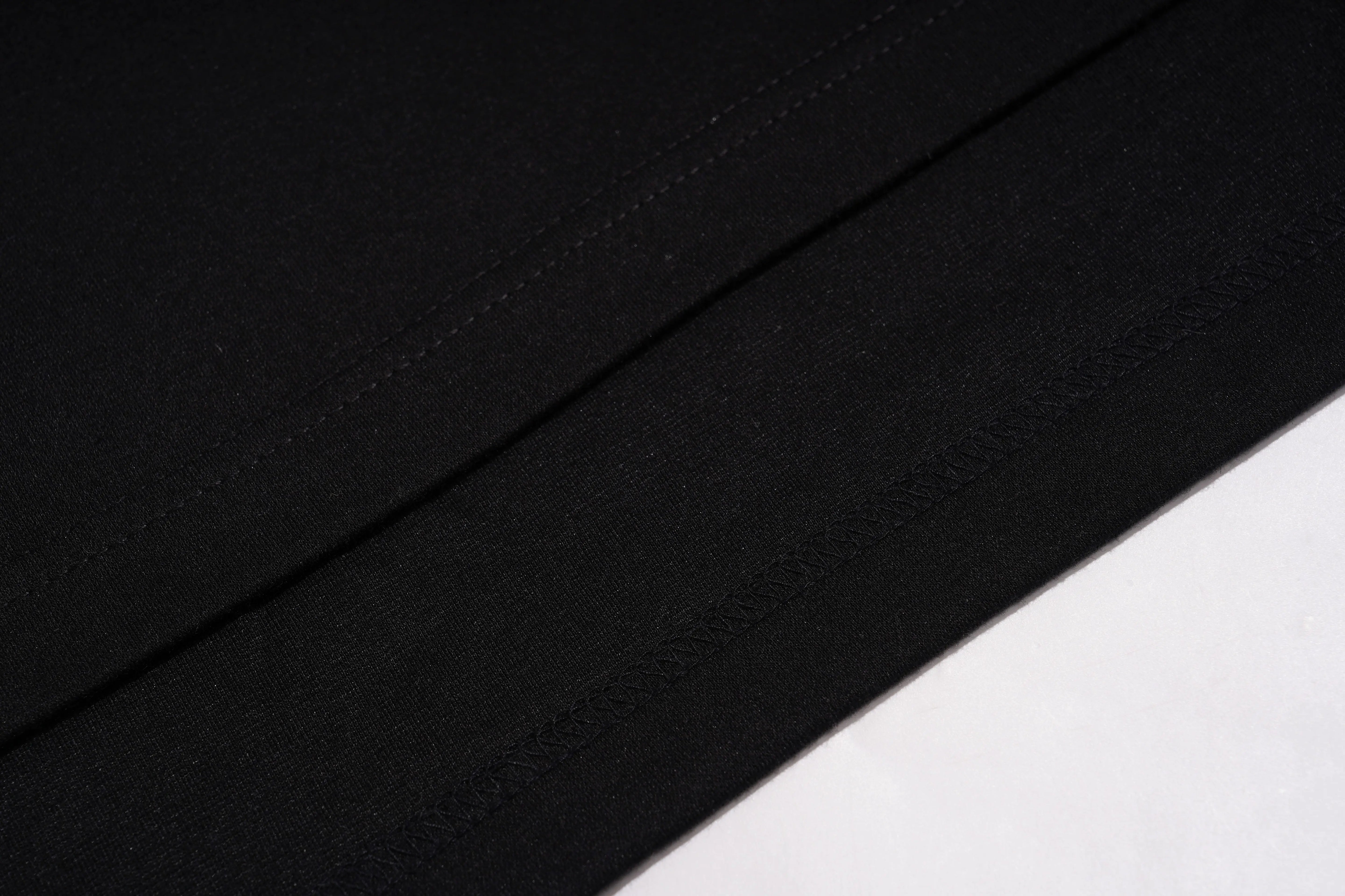 Close-up of black fabric with a subtle texture on a white background, TCH Leopard Rhinestone Sleeveless Polo Shirt