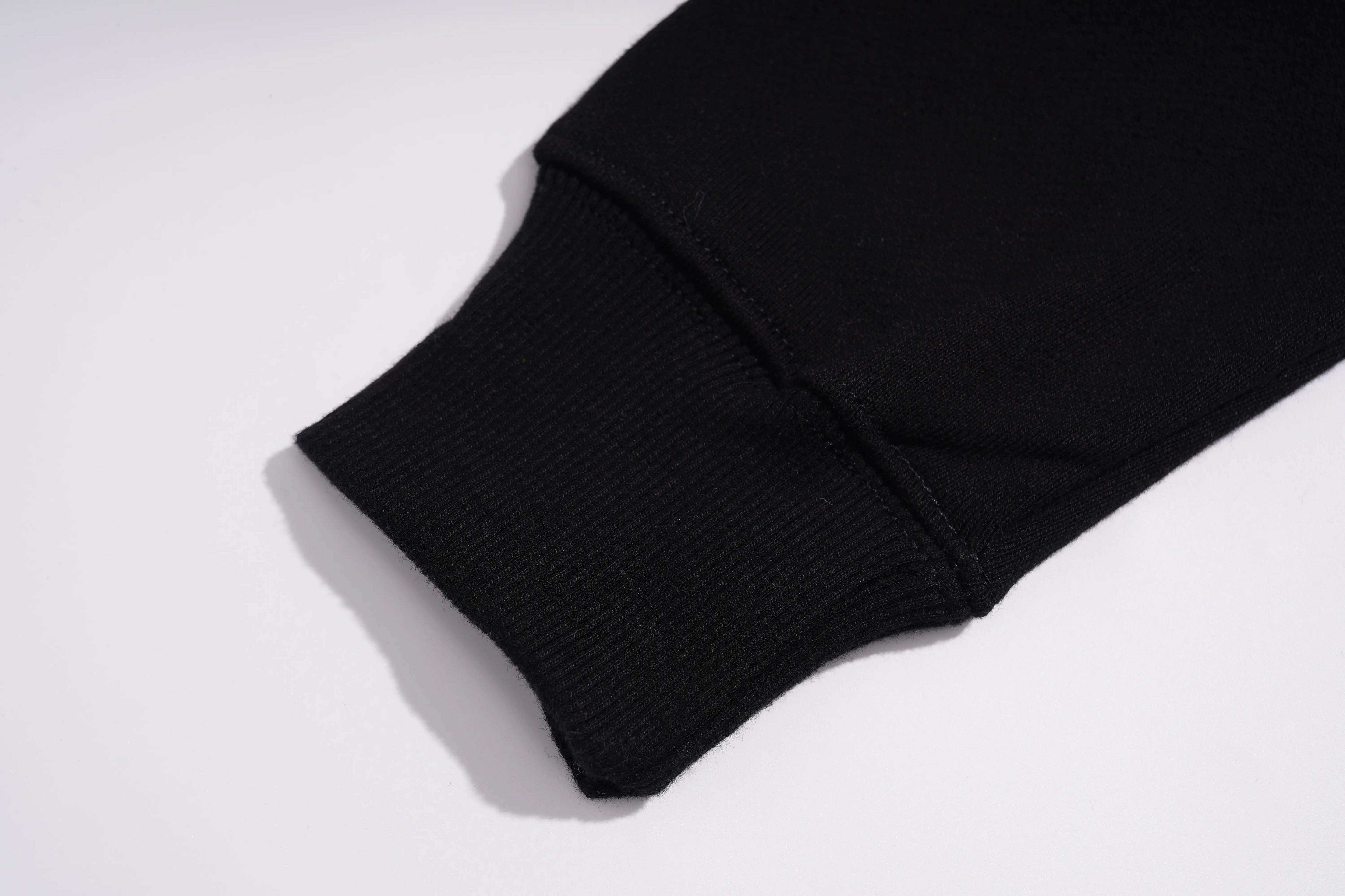 Close-up of a black ribbed knit sleeve cuff on a white background. TCH Luxury Gold Dragon Rhinestone Graphic Black Sweatshirt