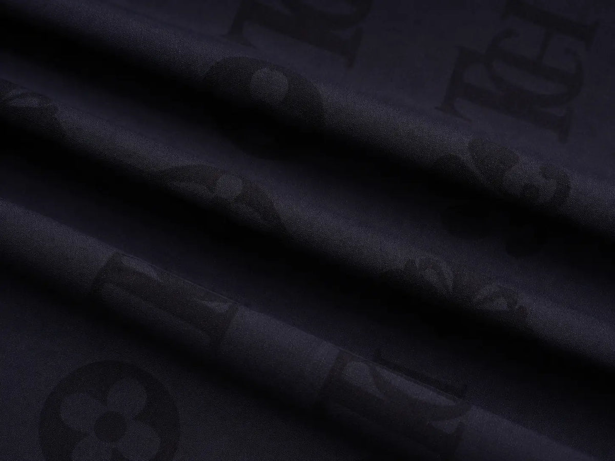 Dark navy blue fabric with a subtle tonal monogram pattern featuring a flower and script lettering. TCH Luxury Monogram Hooded Windbreaker Jacket
