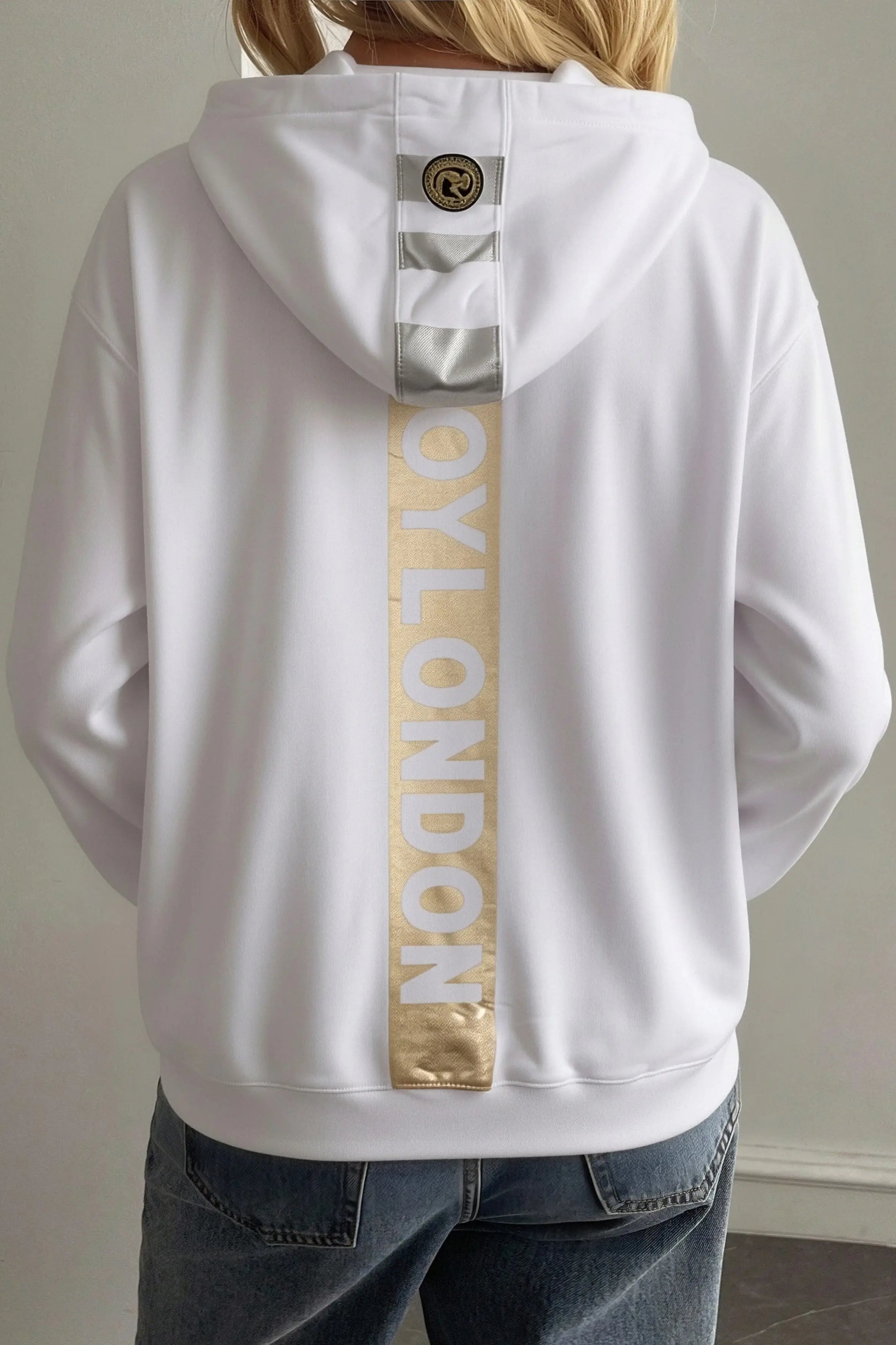 White hoodie with gold 'OY London' text on the back, worn by a person. TCH Mech Graphic Rhinestone Crew Neck Sweatshirt