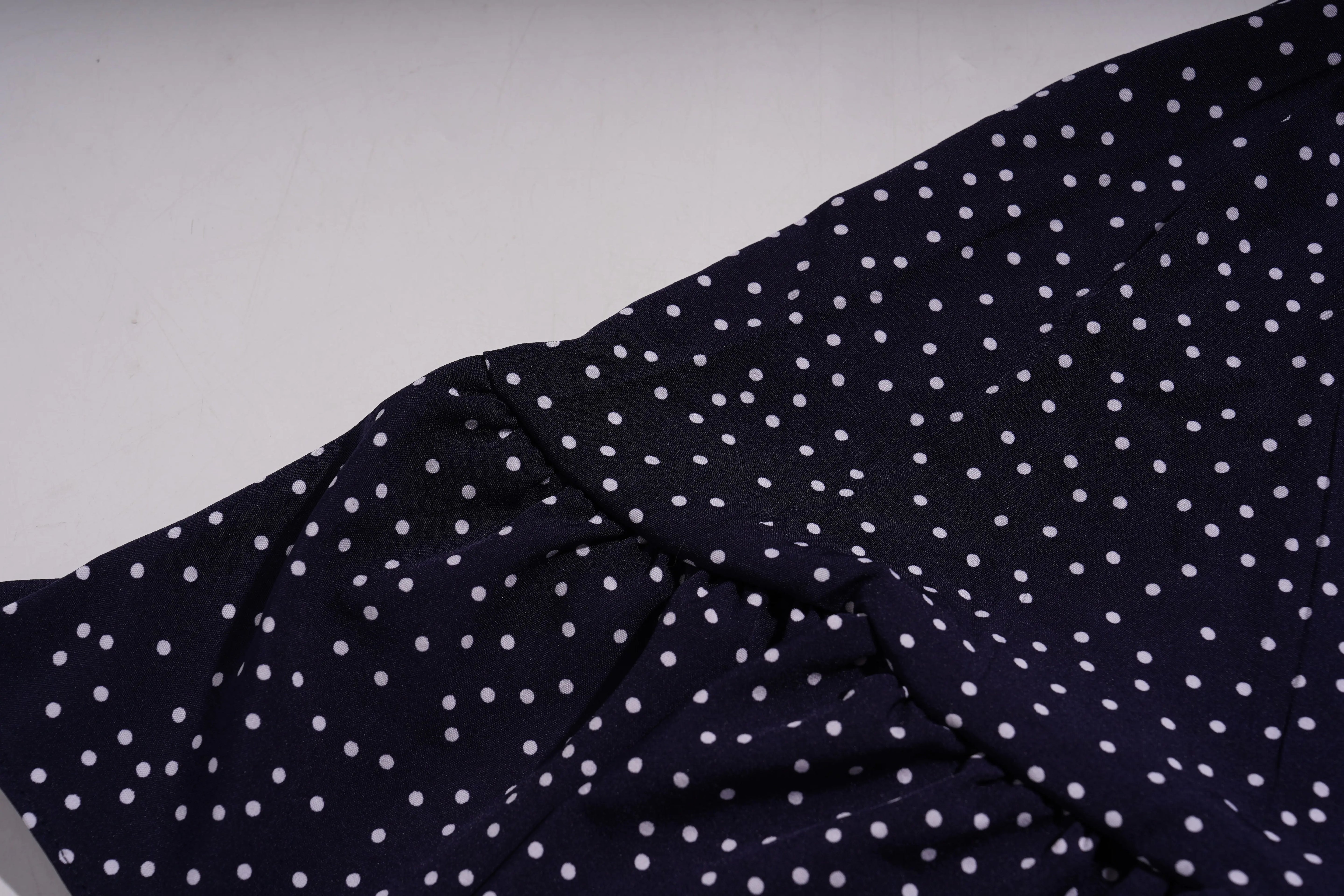 Navy blue fabric with white polka dots on a light gray background, TCH Navy Teddy Bear Bow Rhinestone Dress