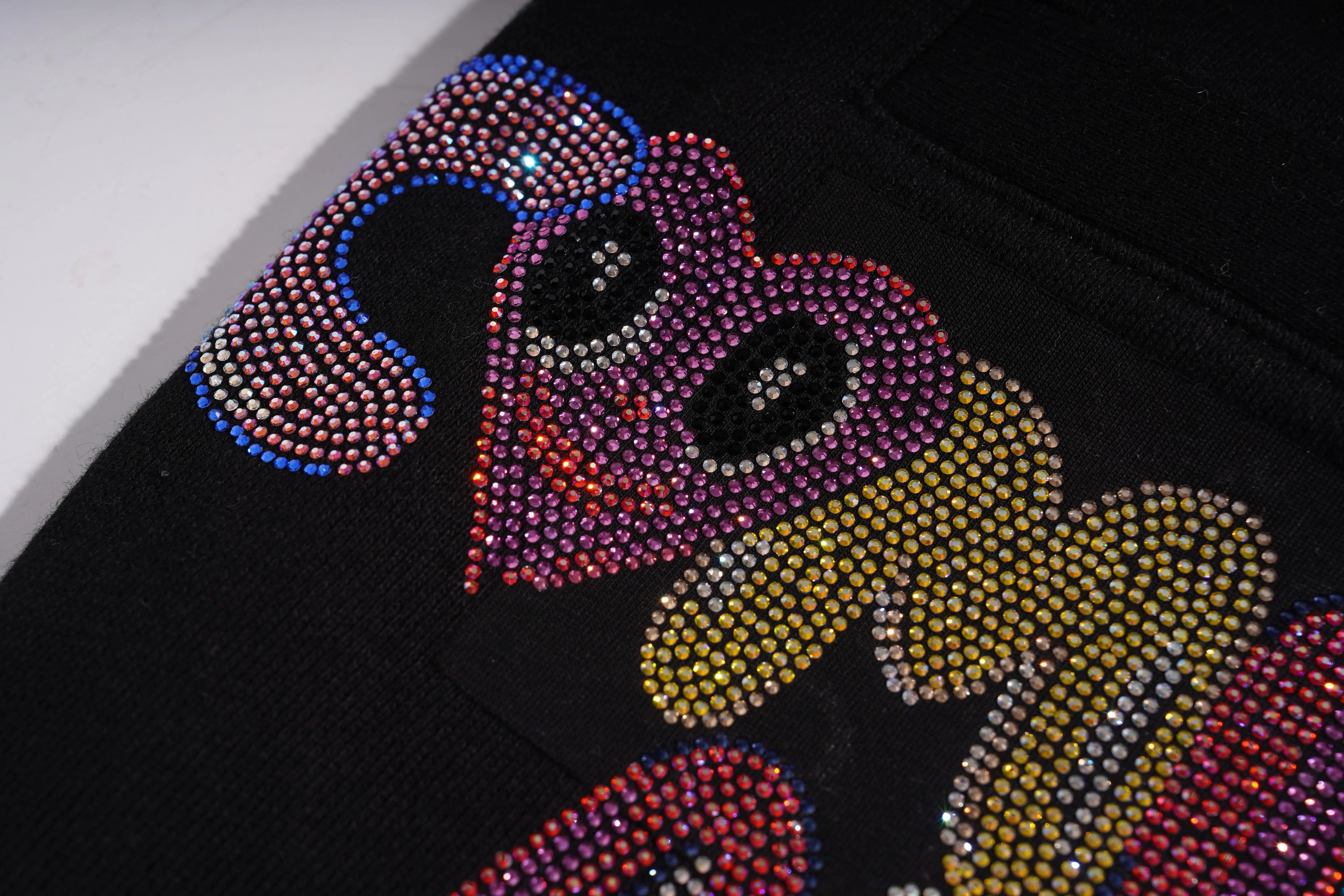Close-up of a colorful snake design made with rhinestones on black fabric. TCH Panda Rhinestone Black Jogger Pants
