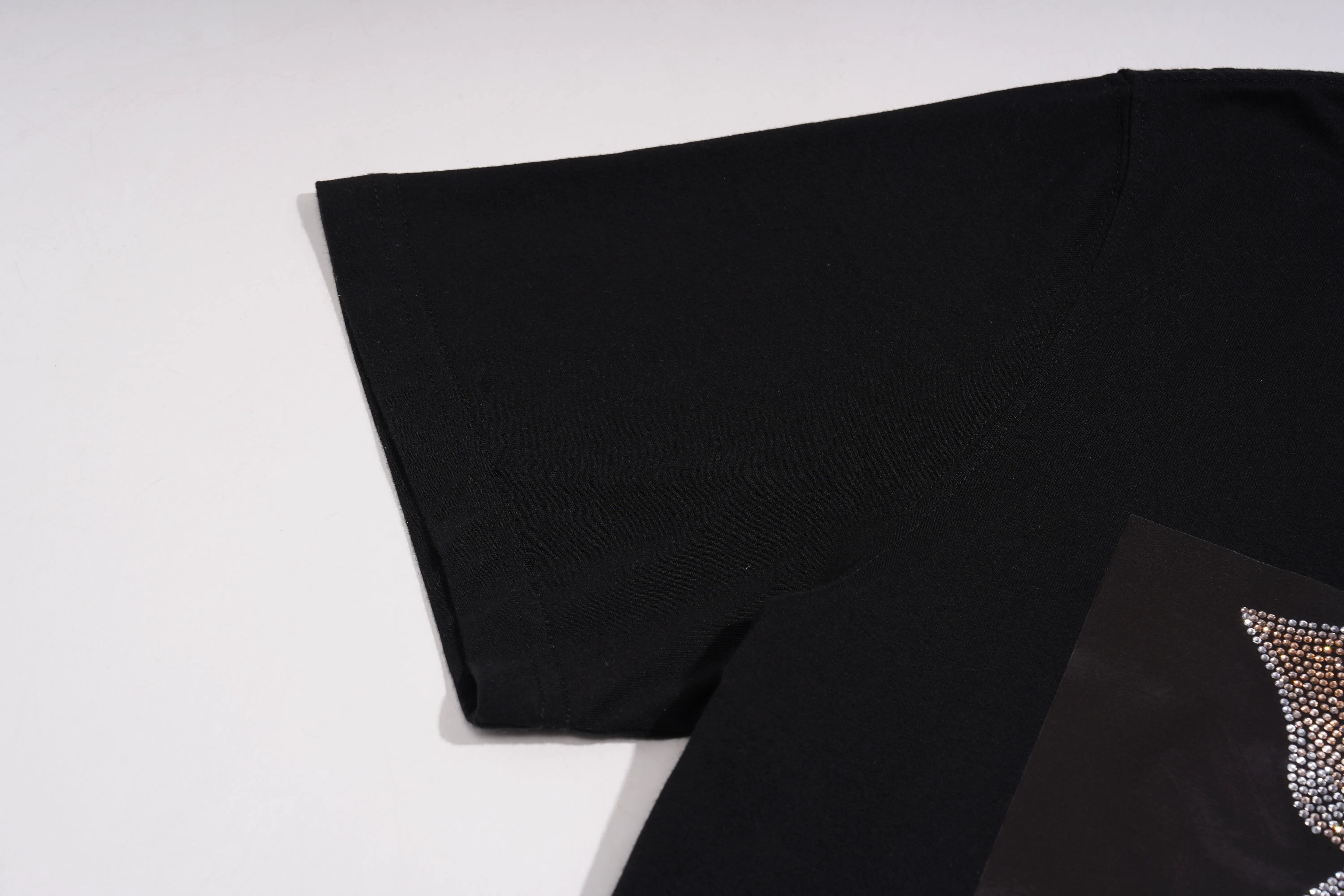 Black fabric with a decorative pattern on a white background, TCH Piggy Techno Rhinestone T-Shirt