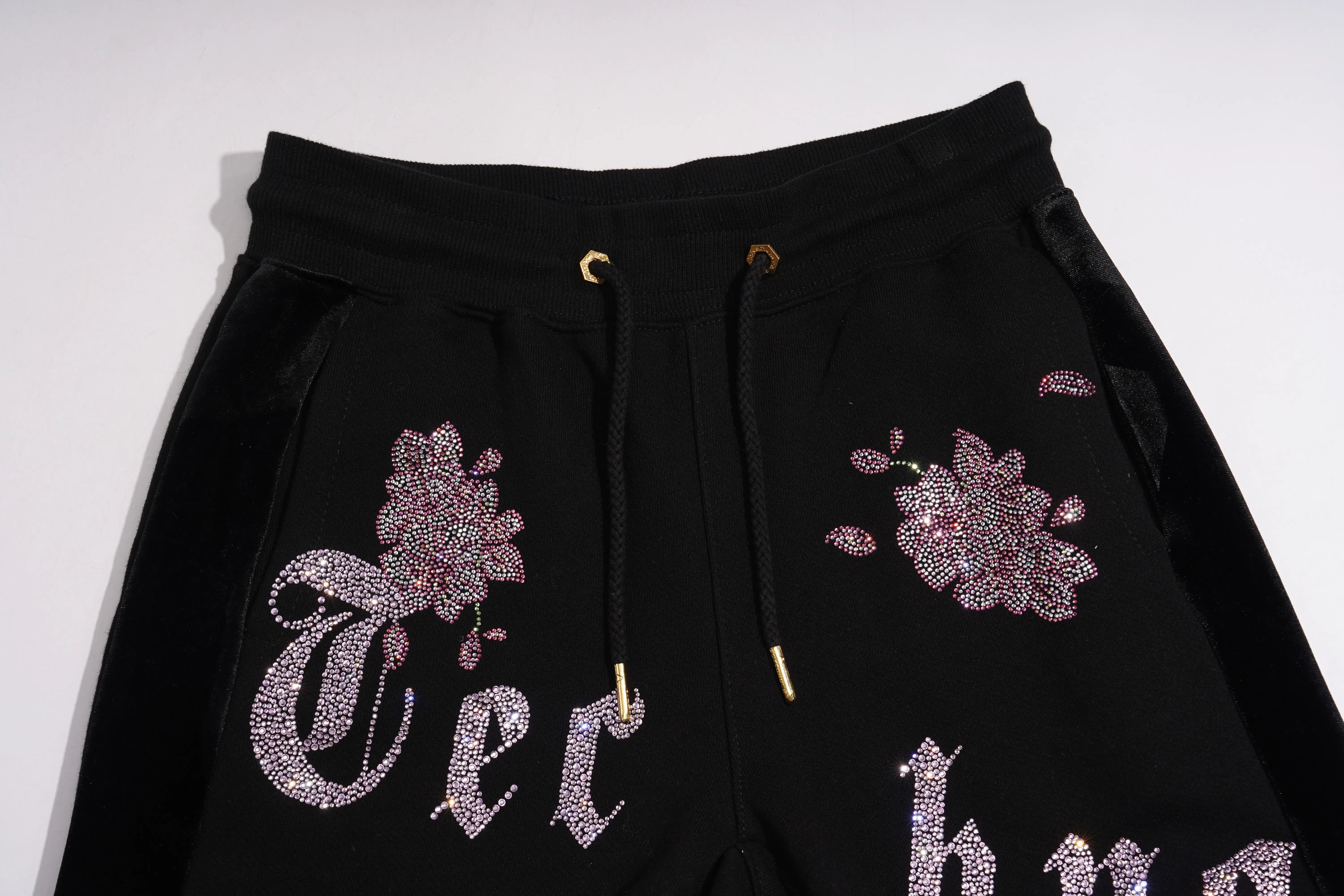 Black sweatpants with floral and text designs on a white background, TCH Pink Blossom Rhinestone Jogger Pants