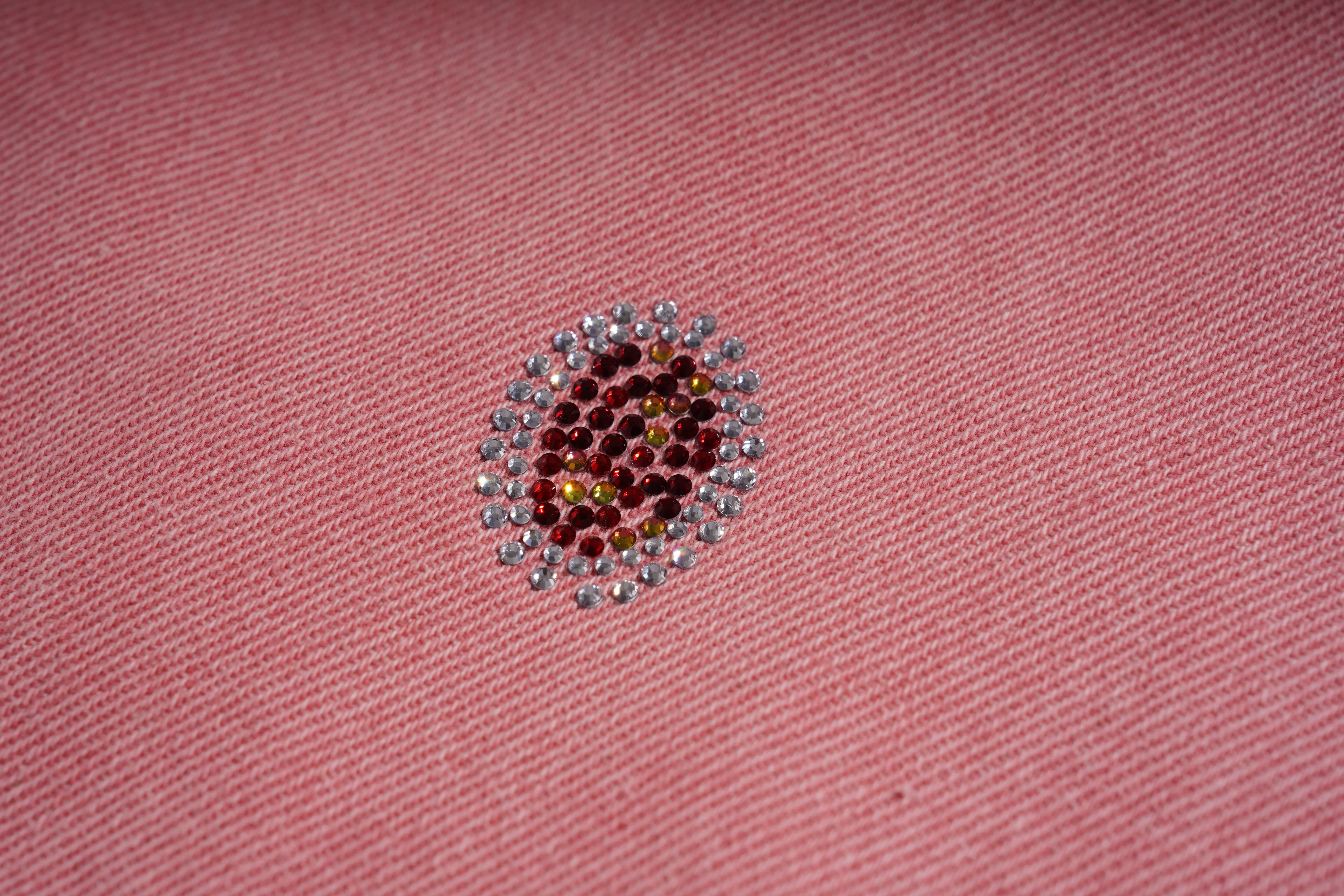 Close-up of a pink fabric with a decorative bead pattern, TCH Pink Moonlight Rhinestone Denim Jeans