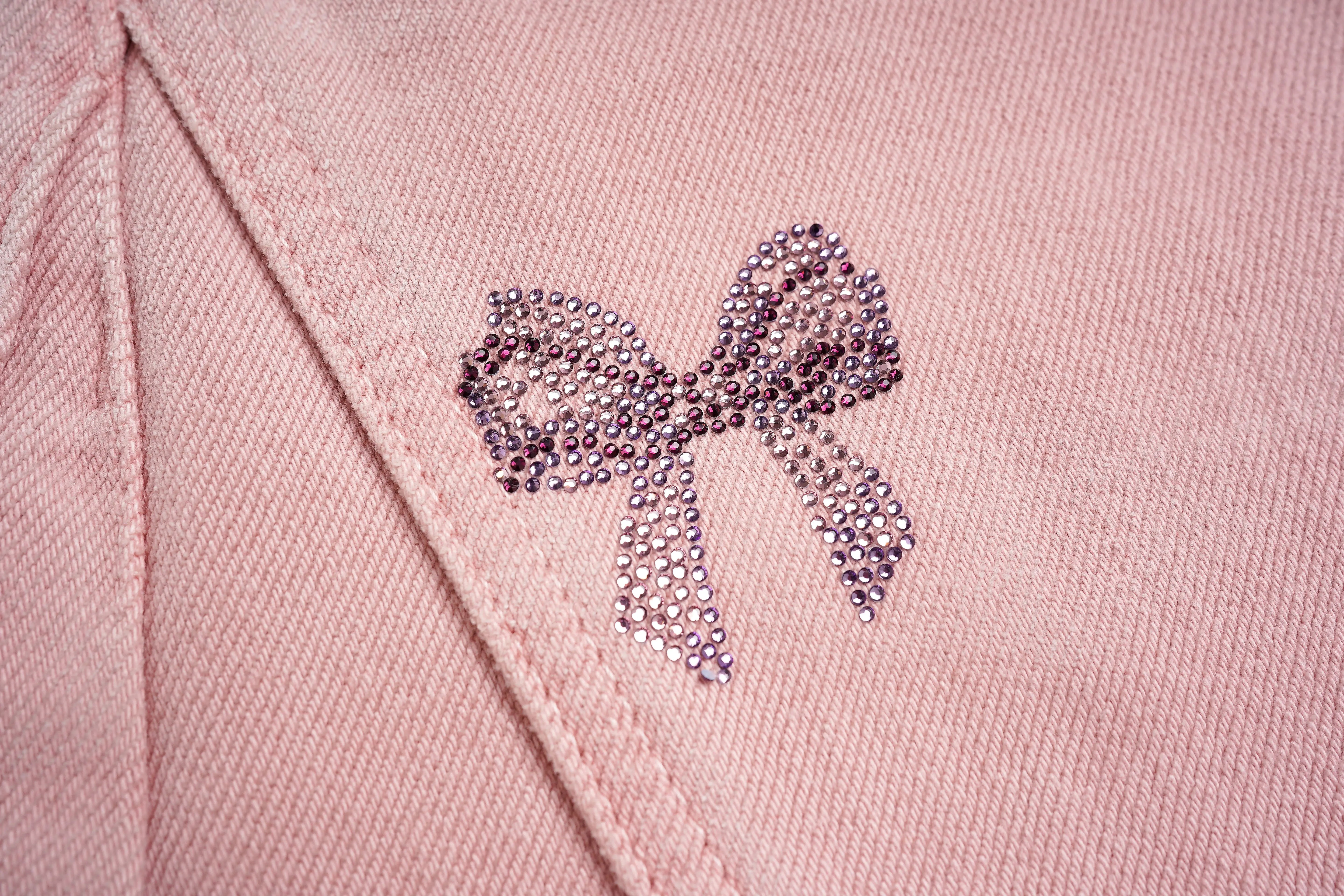 Close-up of a pink fabric with a decorative bow made of small crystals. TCH Pink Rhinestone Bear & Floral Wide-Leg Pants