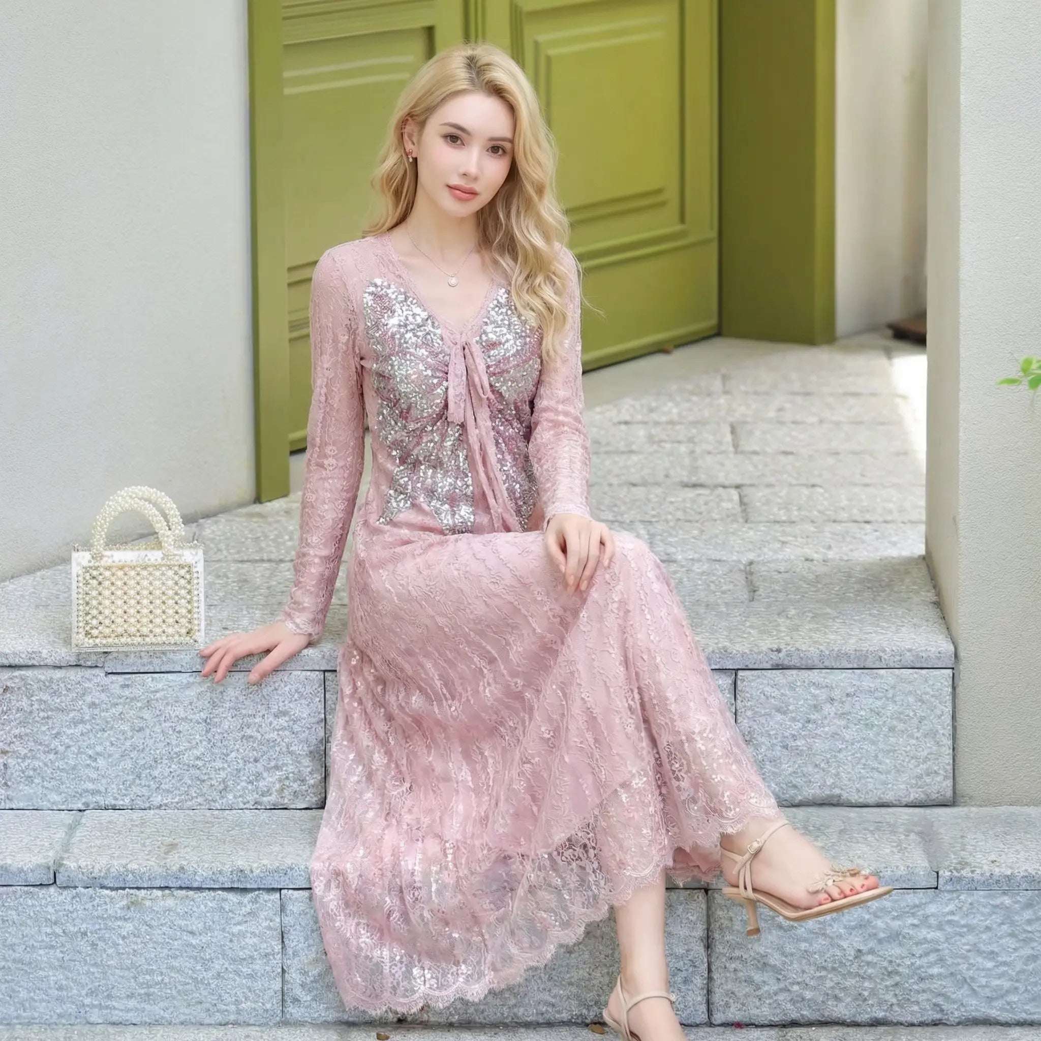Woman in a pink lace dress sitting on steps with a green door in the background, TCH Pink Rhinestone Bow Lace Layered Dress