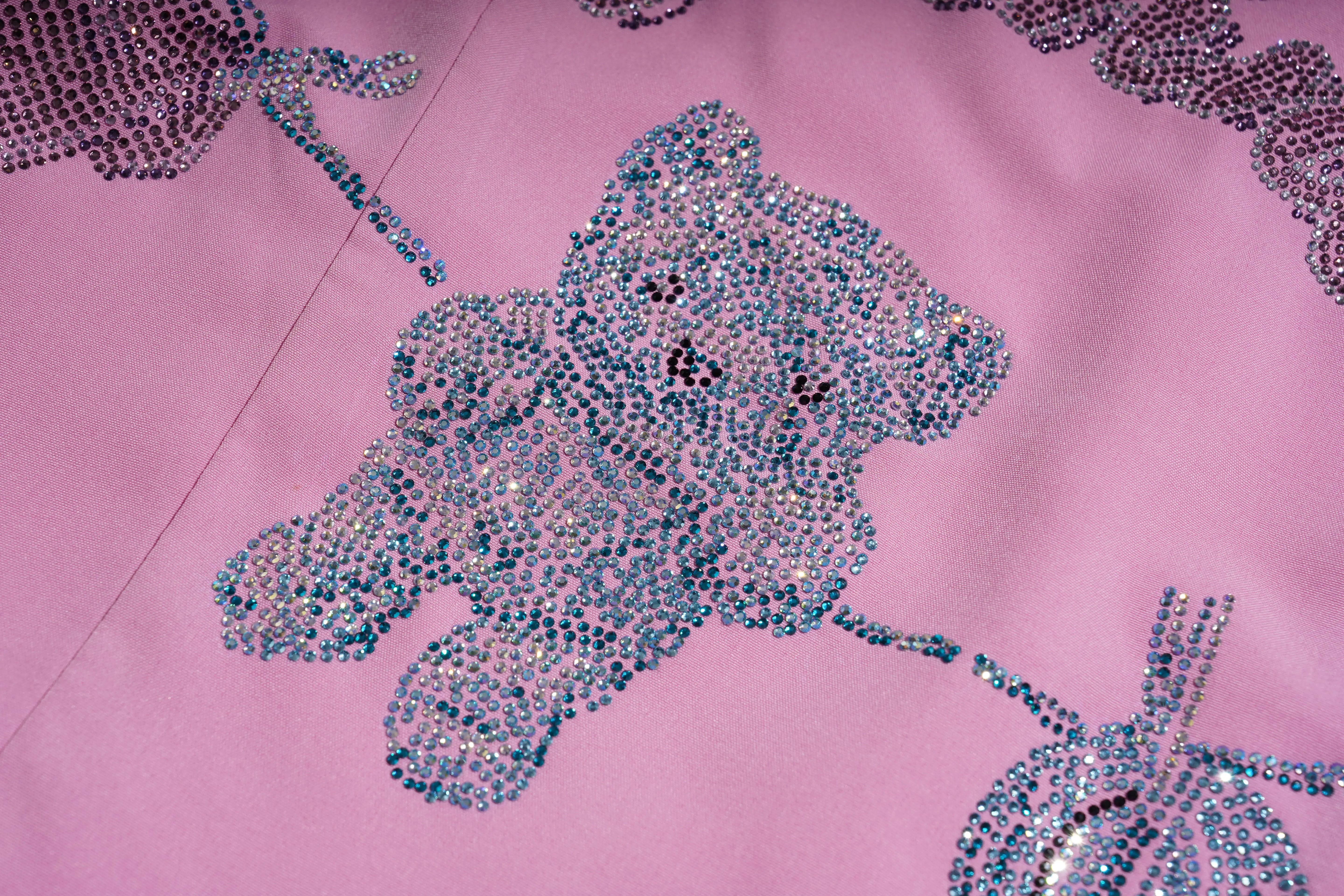 Close-up of a pink fabric with a teddy bear design made of blue rhinestones. TCH Pink Rhinestone Teddy Laundry Story Dress