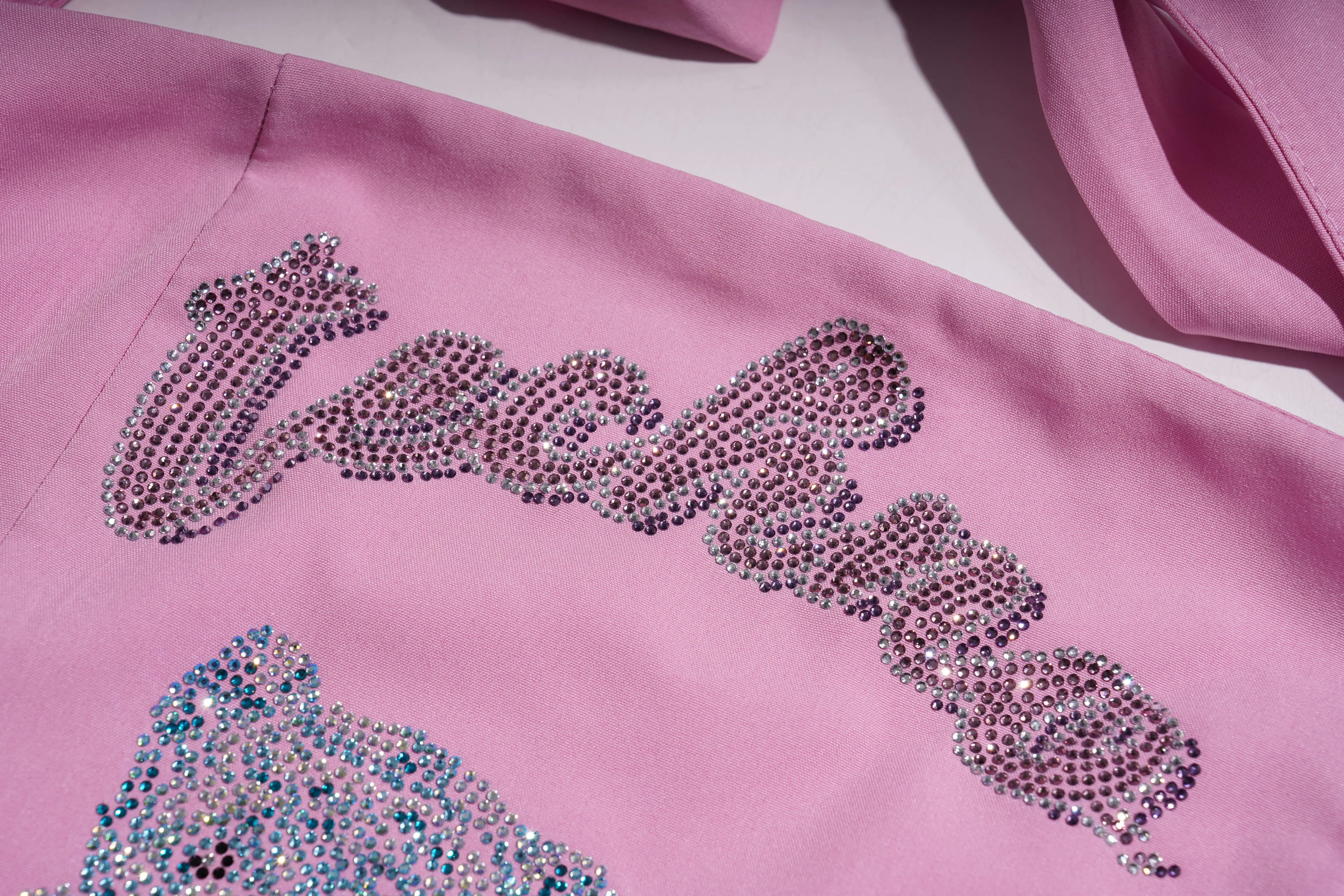 Pink fabric with 'Juicy' text in rhinestones on a white background, TCH Pink Rhinestone Teddy Laundry Story Dress