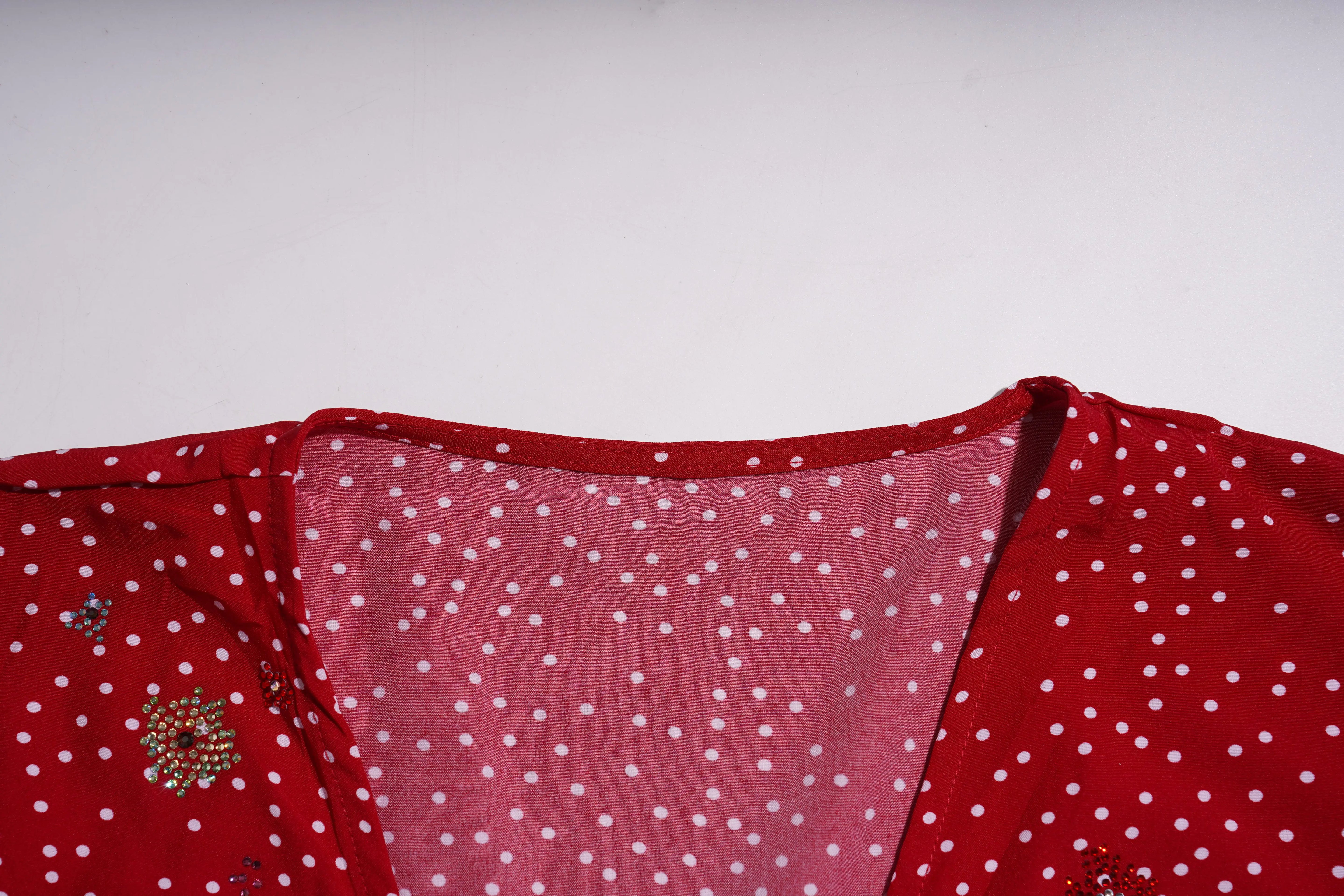 Red fabric with white polka dots and decorative elements on a light gray background, TCH Red Polka Dot Rhinestone Flower Dress