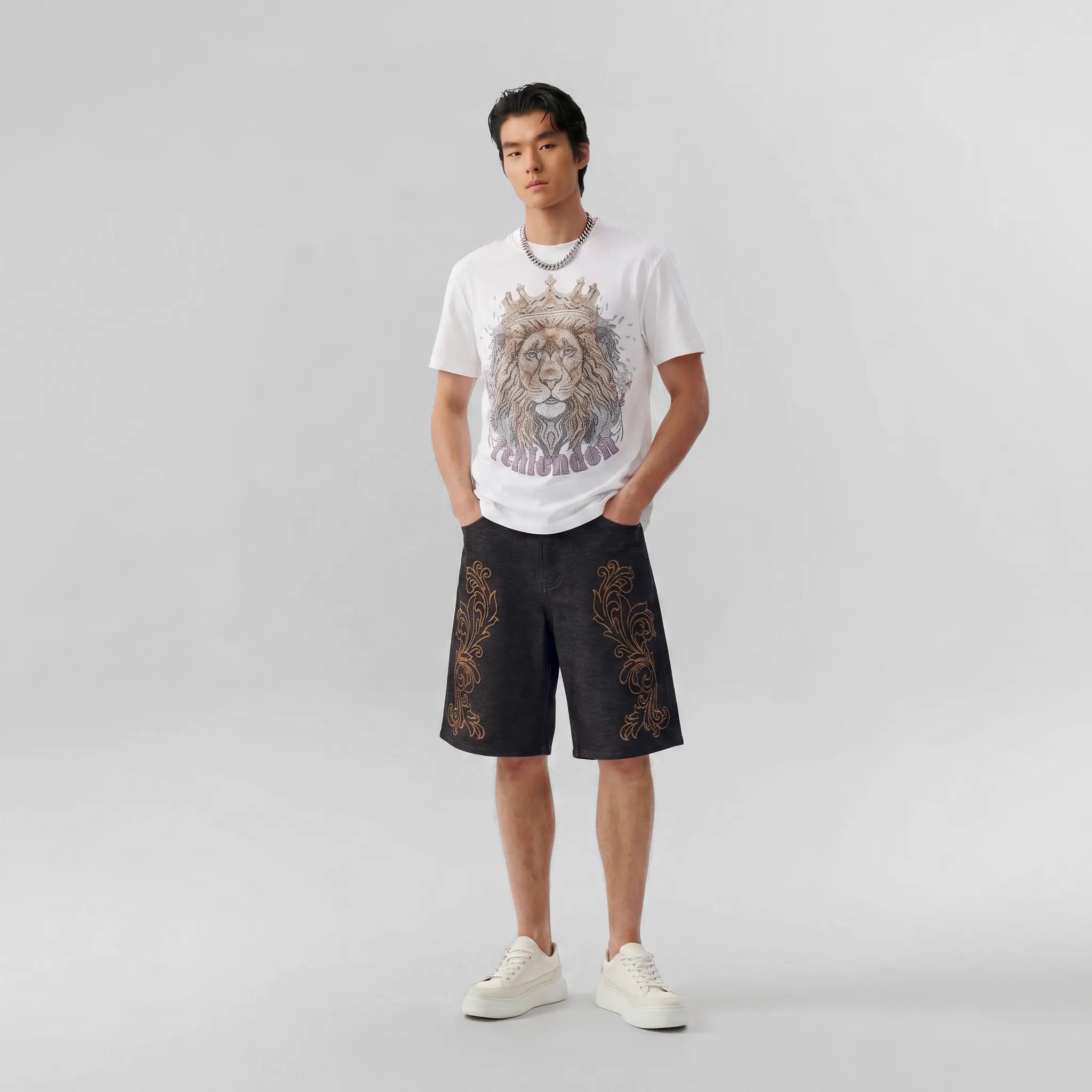A black short-sleeve t-shirt with an all-over white graffiti-style text print, shown from both the front and back views against a plain white background. TCH Regal Crown Lion Rhinestone Graphic T-Shirt